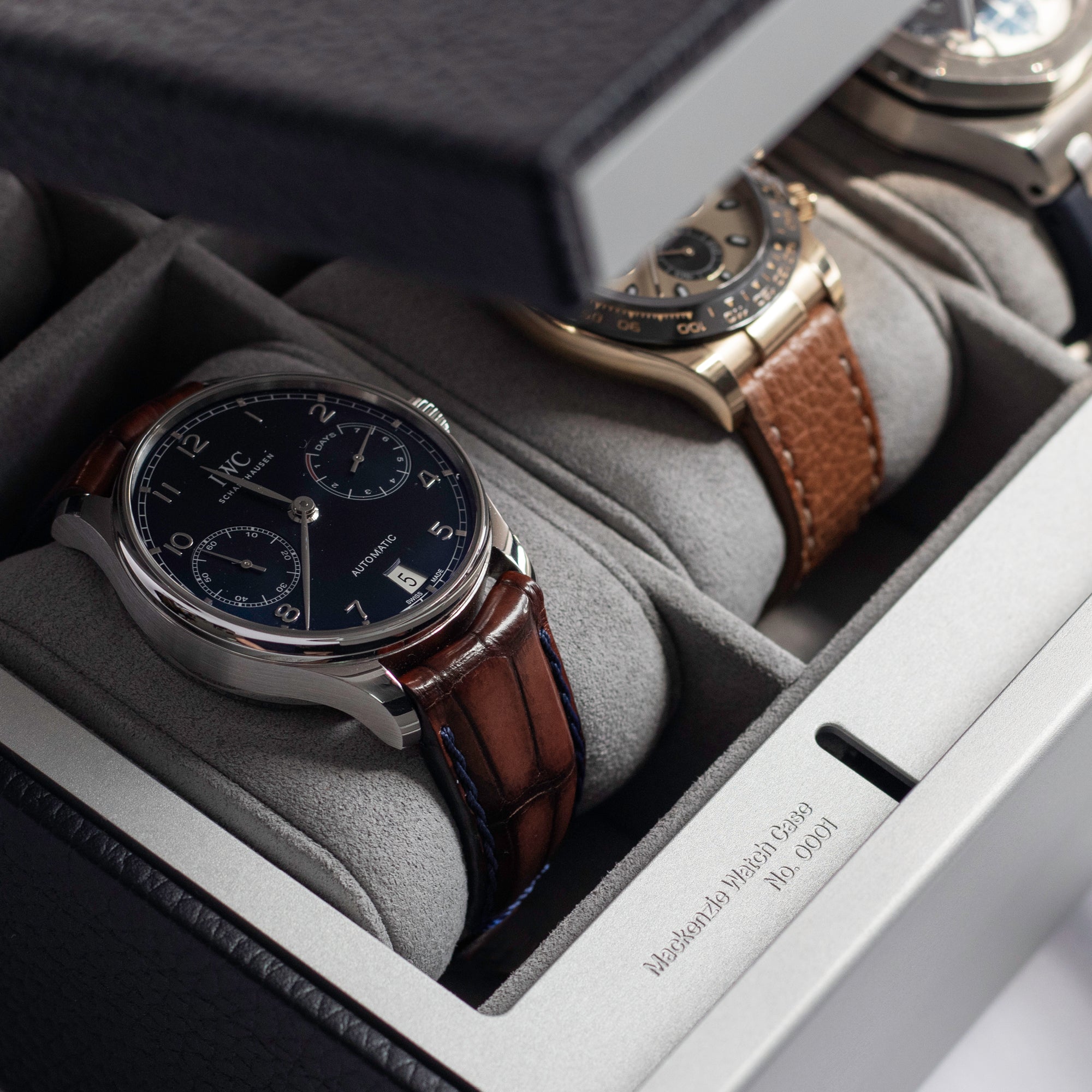 Closeup shot of Mackenzie 10 Watch briefcase in black leather showcasing sleek grey aluminum and wood handle and lock with code
