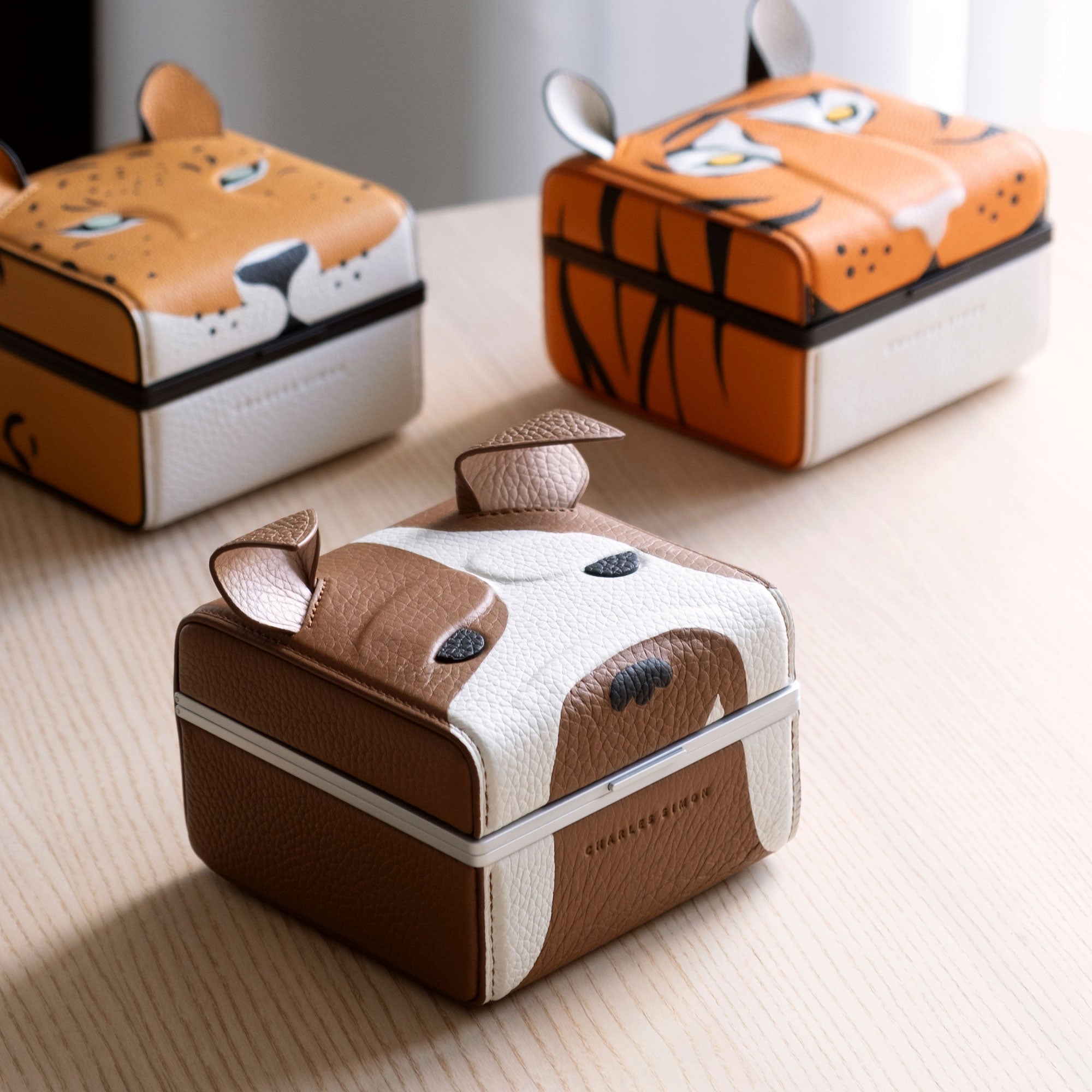 Lifestyle photo of the Eaton 1 special edition watch cases, with the bulldog watch case in the front center, the leopard watch case on the left and the tiger watch case on the right.