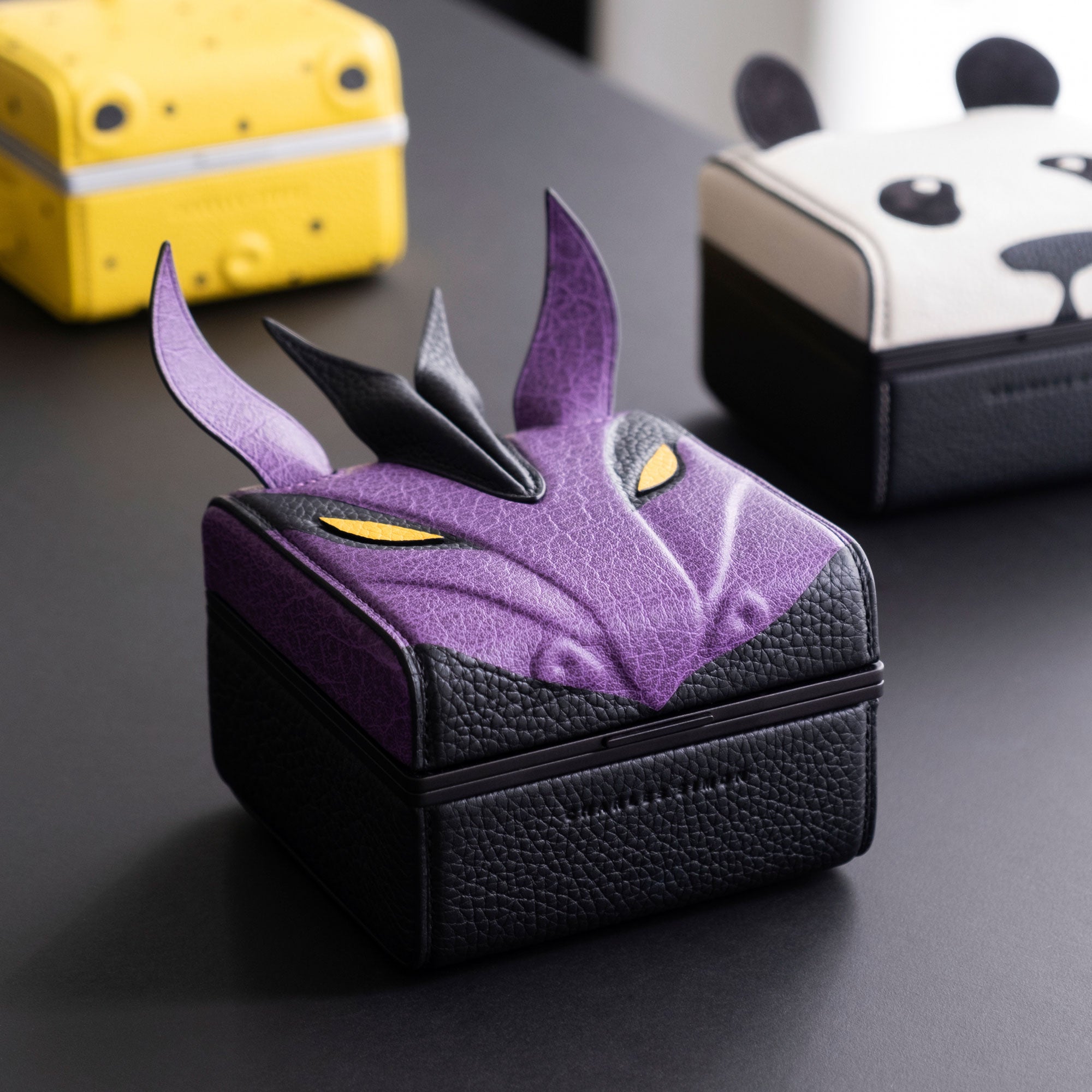 Lifestyle photo of the purple Eaton 1 watch case surrounded by other special edition Eaton 1 watch cases featuring animal designs by Charles Simon.