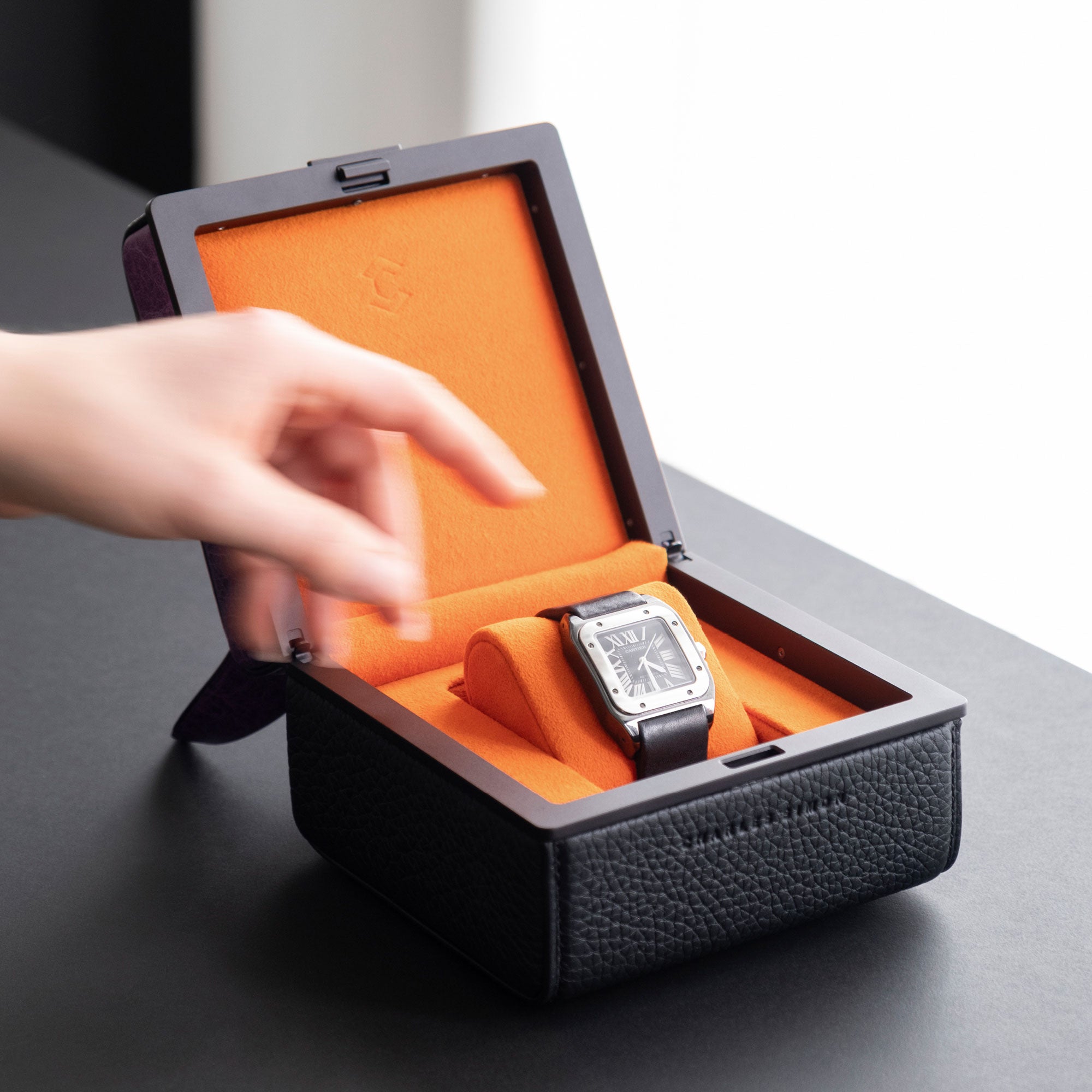 Lifestyle photo of a woman reaching towards the luxury watch displayed in the purple dragon watch case. Handmade in Canada.