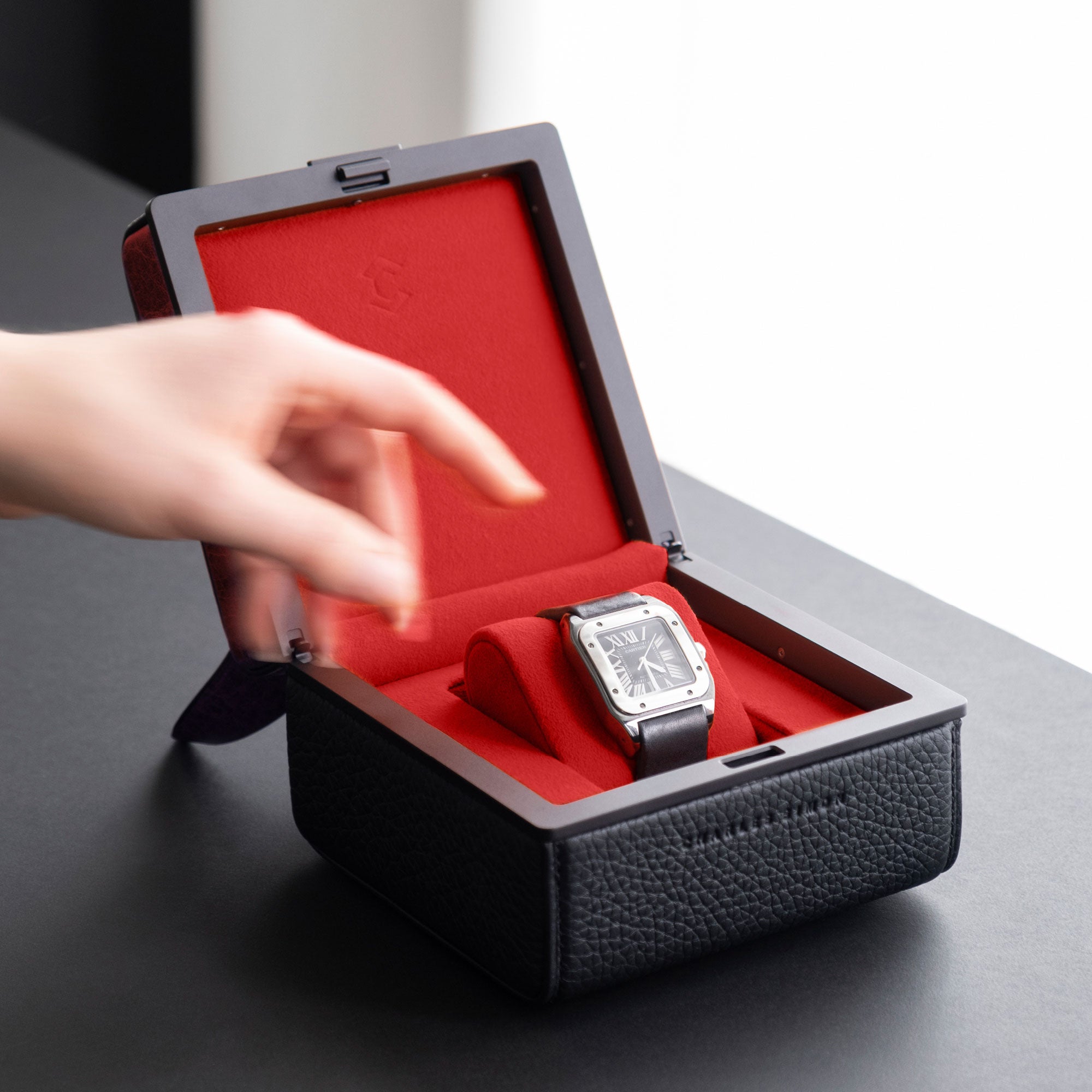 Lifestyle photo of woman reaching for the luxury watch displayed in her red dragon Eaton 1 Watch case. 