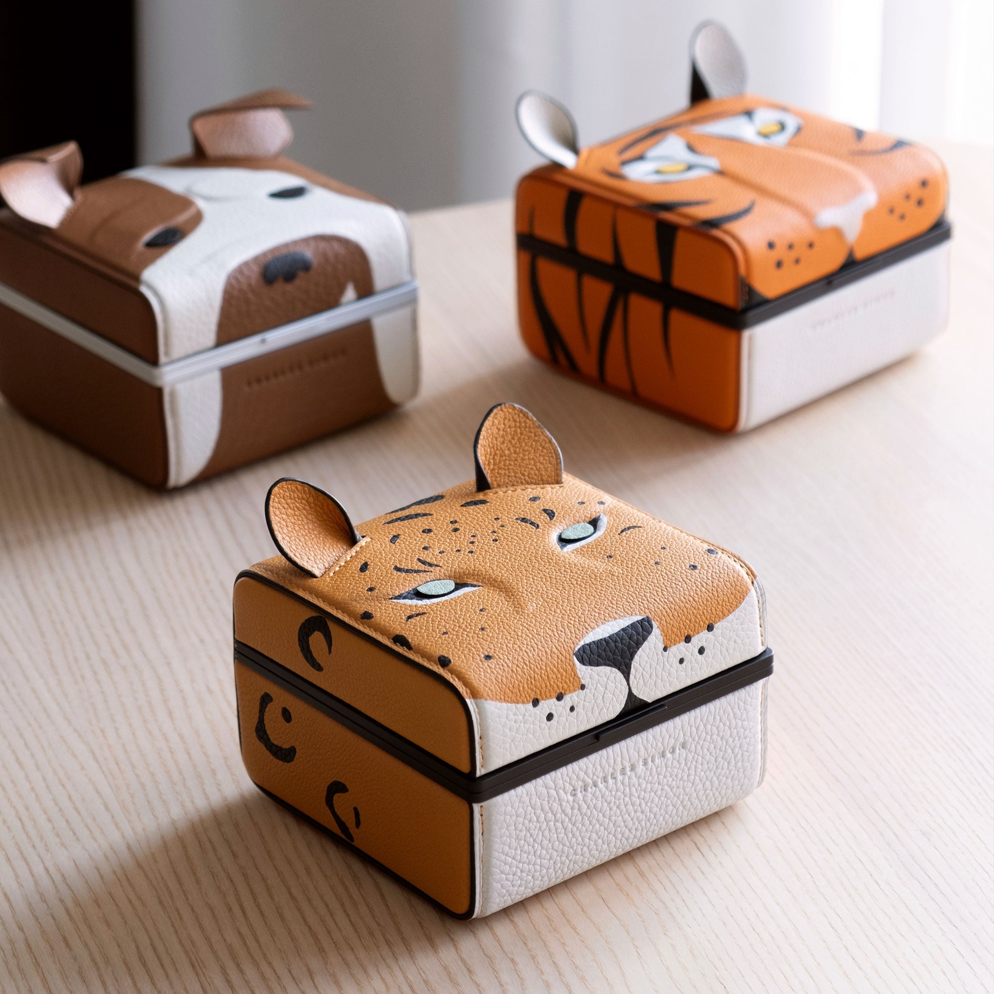 Lifestyle photo of the Eaton 1 special edition watch cases, with the leopard watch case in the front, the bulldog watch case on the left and the tiger watch case on the right.