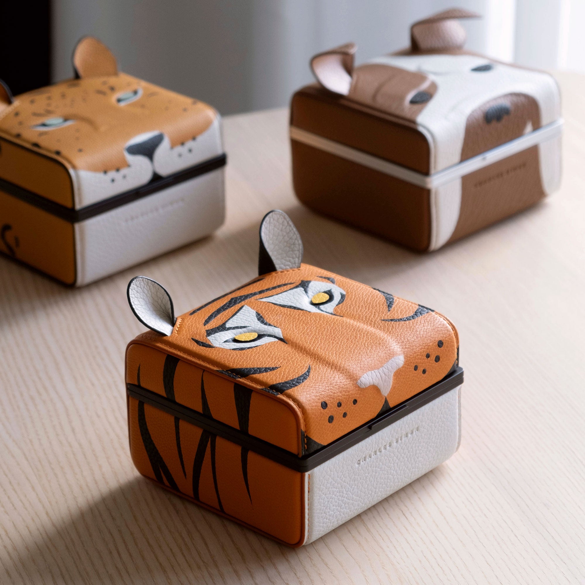 Lifestyle photo of the Eaton 1 special edition watch cases, with the tiger watch case in the front, the leopard watch case on the left and the bulldog watch case on the right.