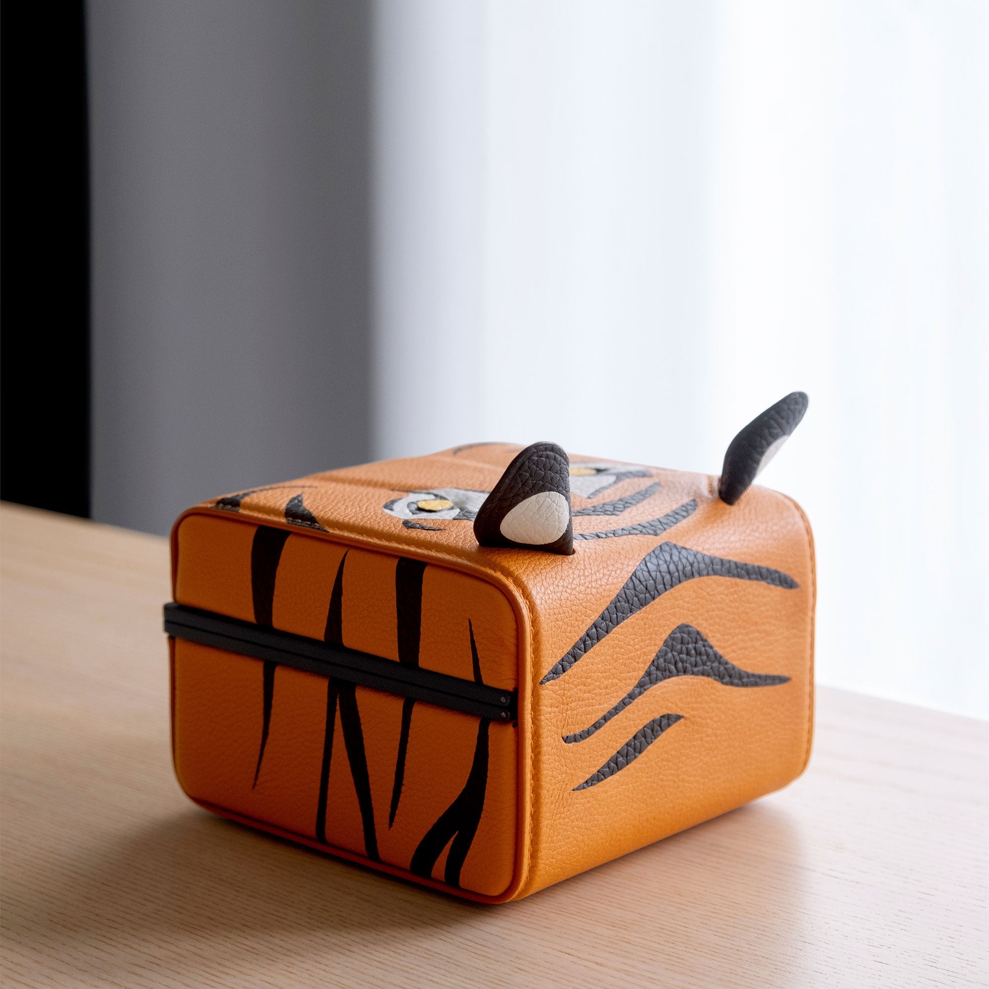 Lifestyle photo of back of the Eaton 1 Tiger Watch Case showcasing intricate leather working details. Handcrafted from premium French leather, soft Alcantara and black anodized aluminum casing.