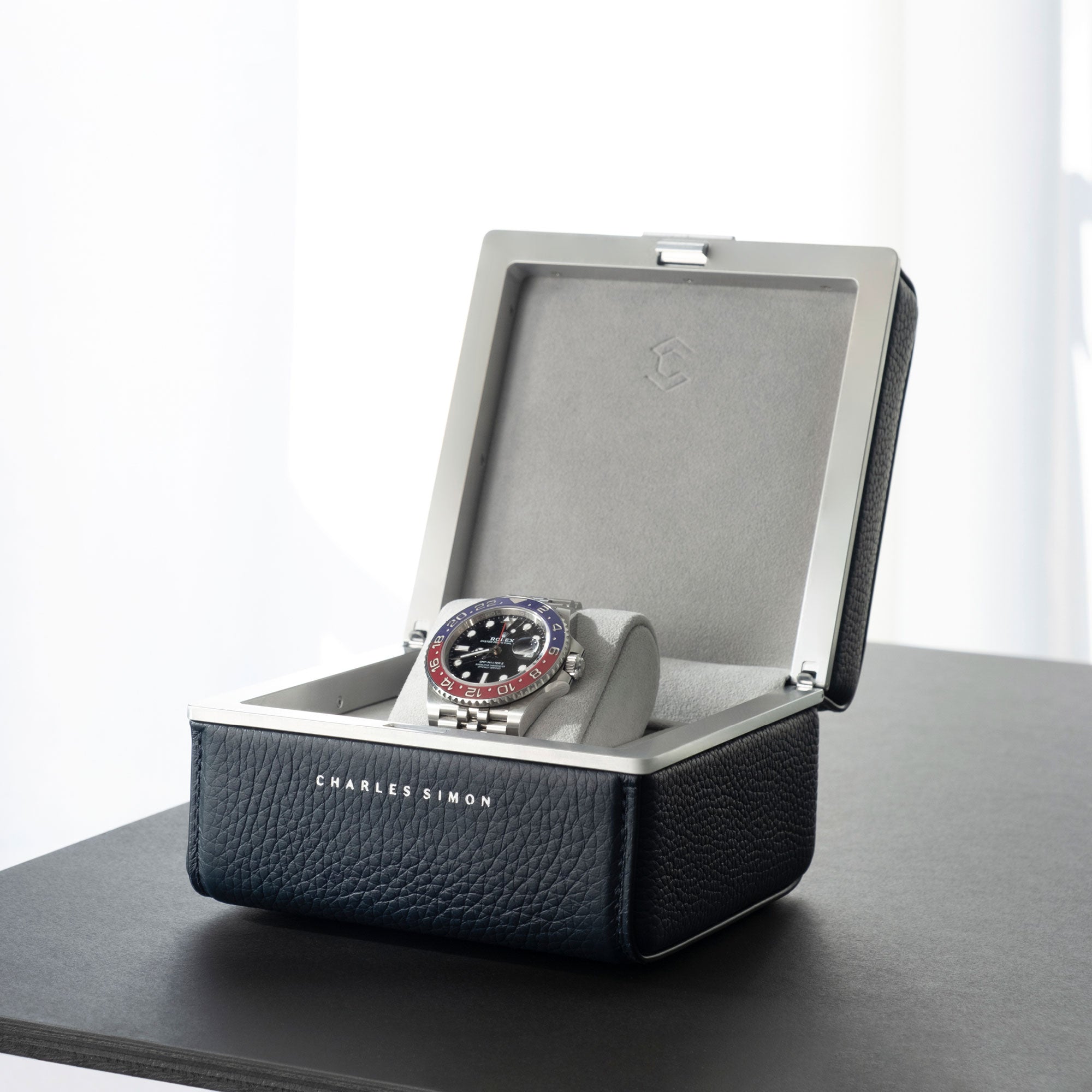 Lifestyle photo of Rolex Pepsi displayed in Eaton 1 Watch case in marine leather and fog grey interior.