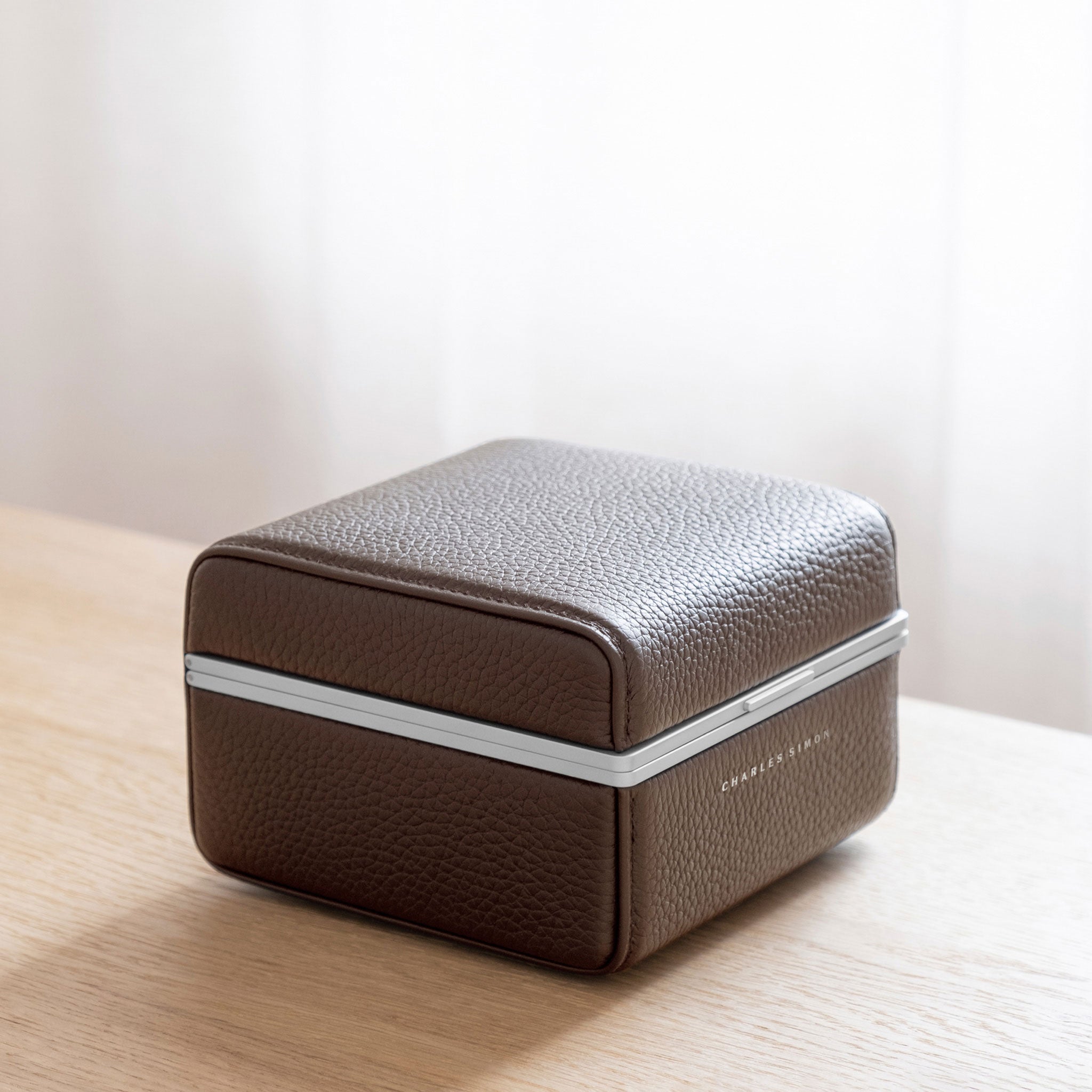 Lifestyle photo of closed Eaton 1 Watch case in tan leather and grey anodized aluminum