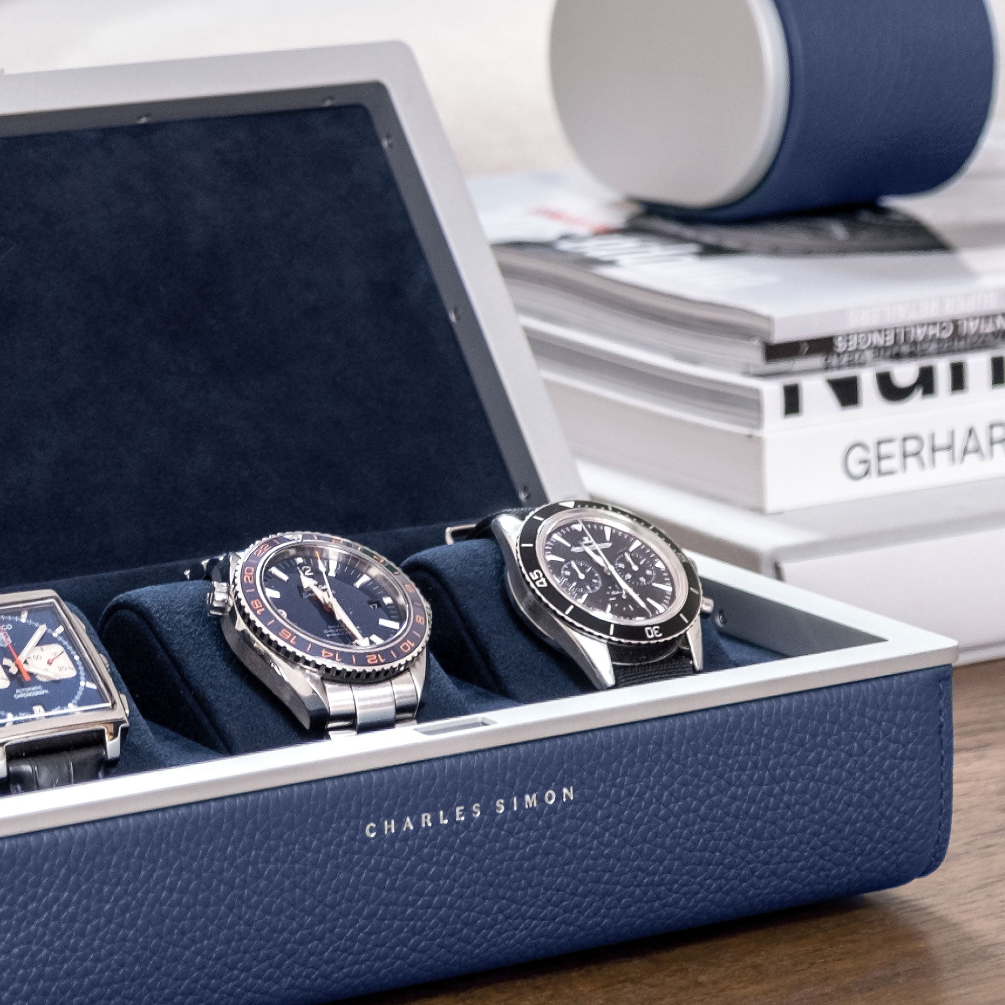 Detail shot of handmade Eaton 3 watch case for 3 watches filled with luxury watches with Theo watch roll in sapphire leather placed in the background.