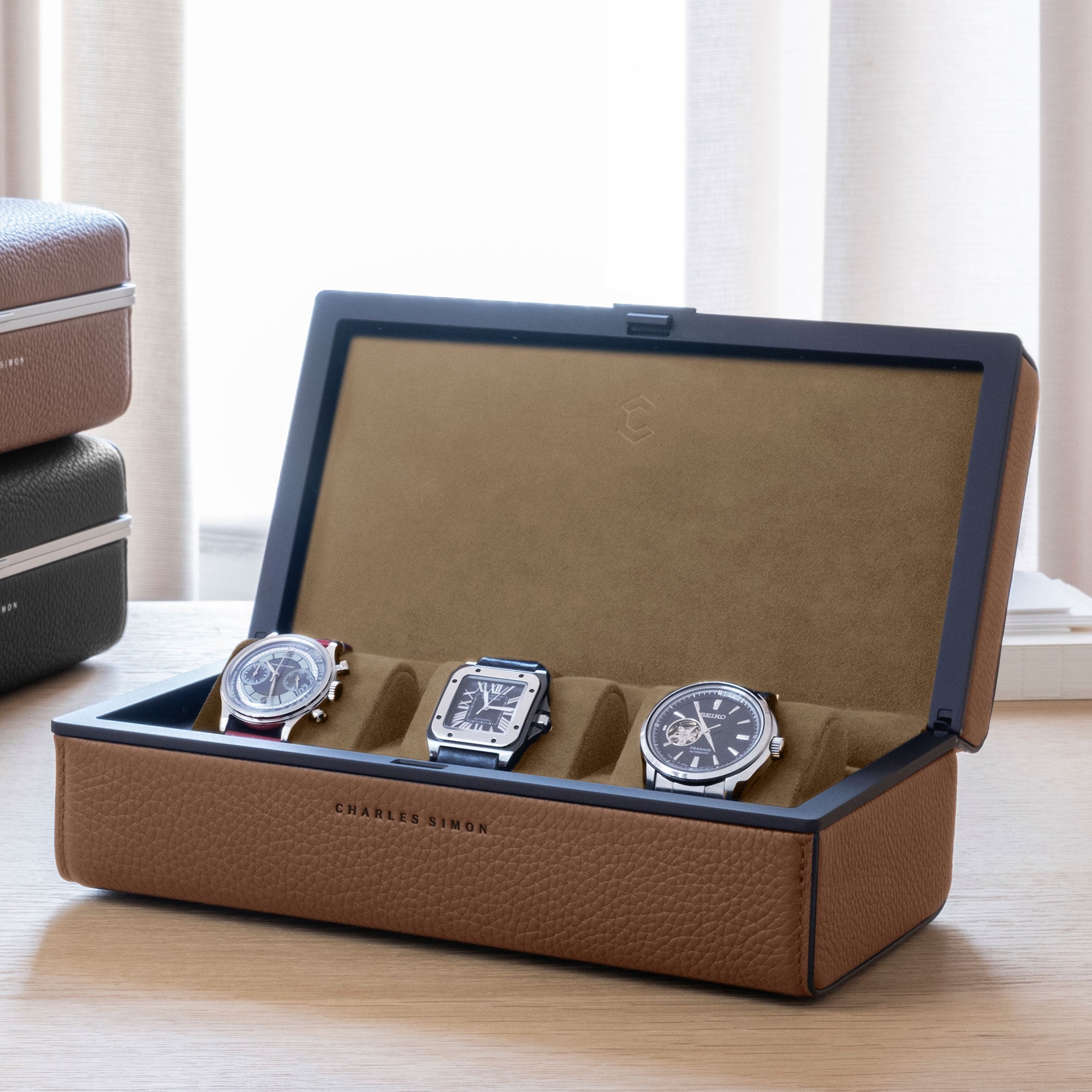 Lifestyle photo of Eaton 3 watch case for 3 watches in tan leather, camel Alcantara and black carbon fiber and anodized aluminum