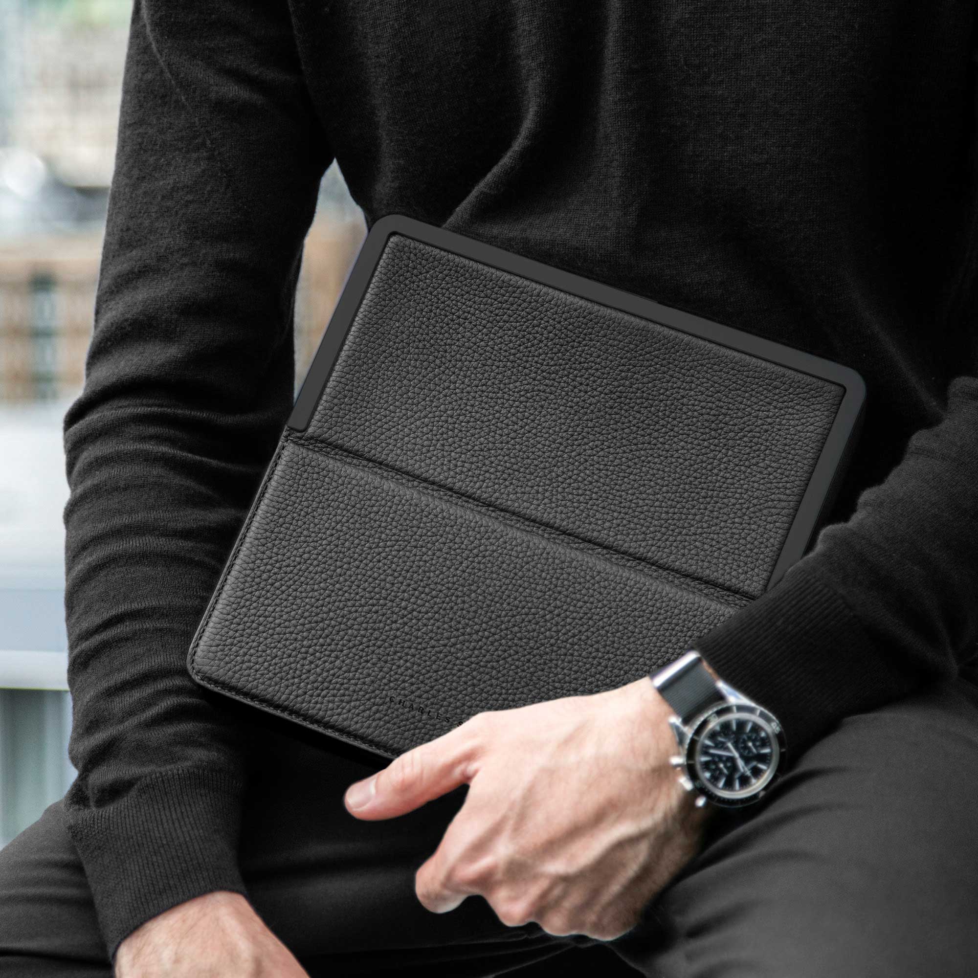 Lifestyle photo of man holding his all black luxury Fraser Travel wallet during his travels.