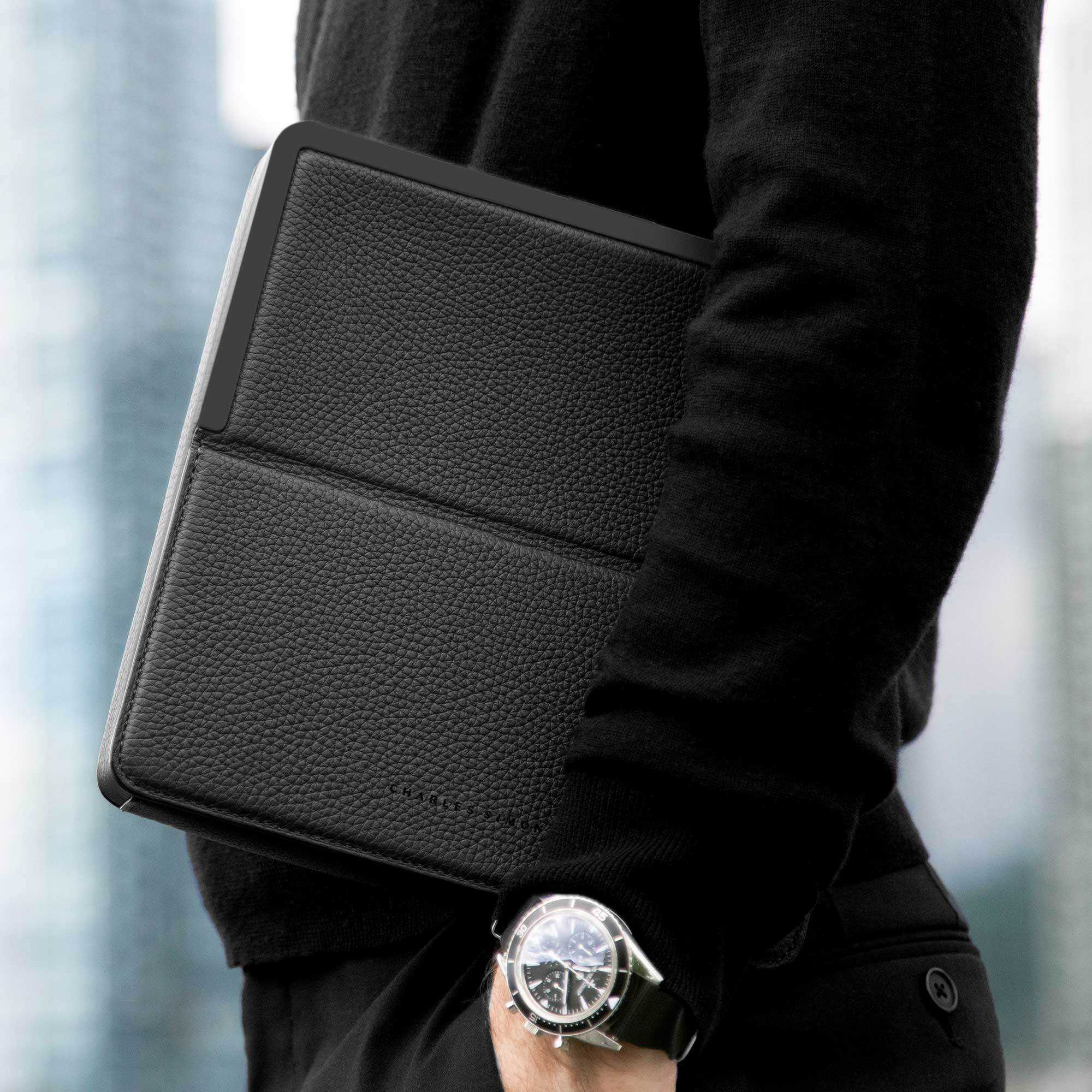 Lifestyle photo of man holding his all black Fraser Travel wallet during his travels.