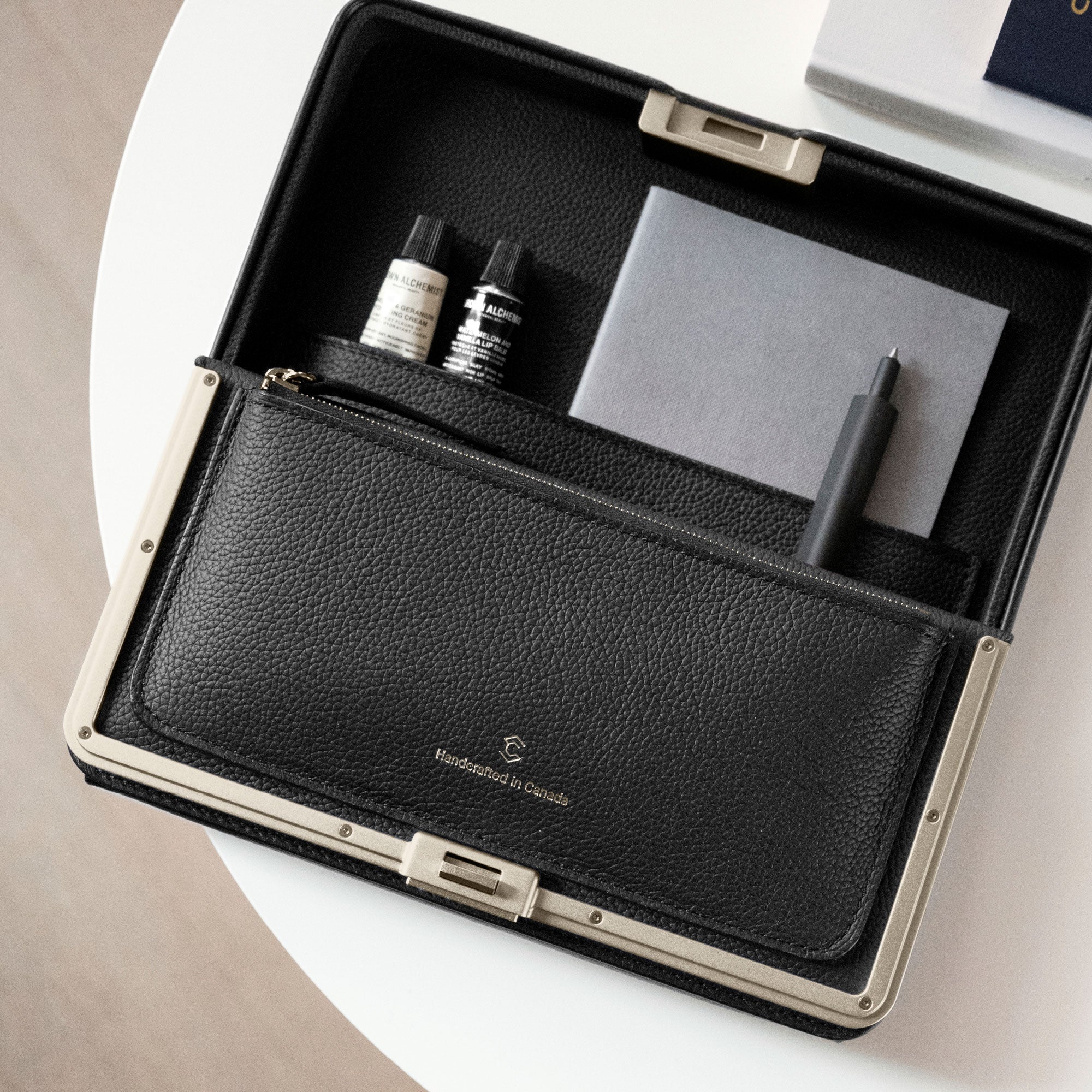 Gold travel wallet holding all travel essentials including a pen, notebook and hand cream