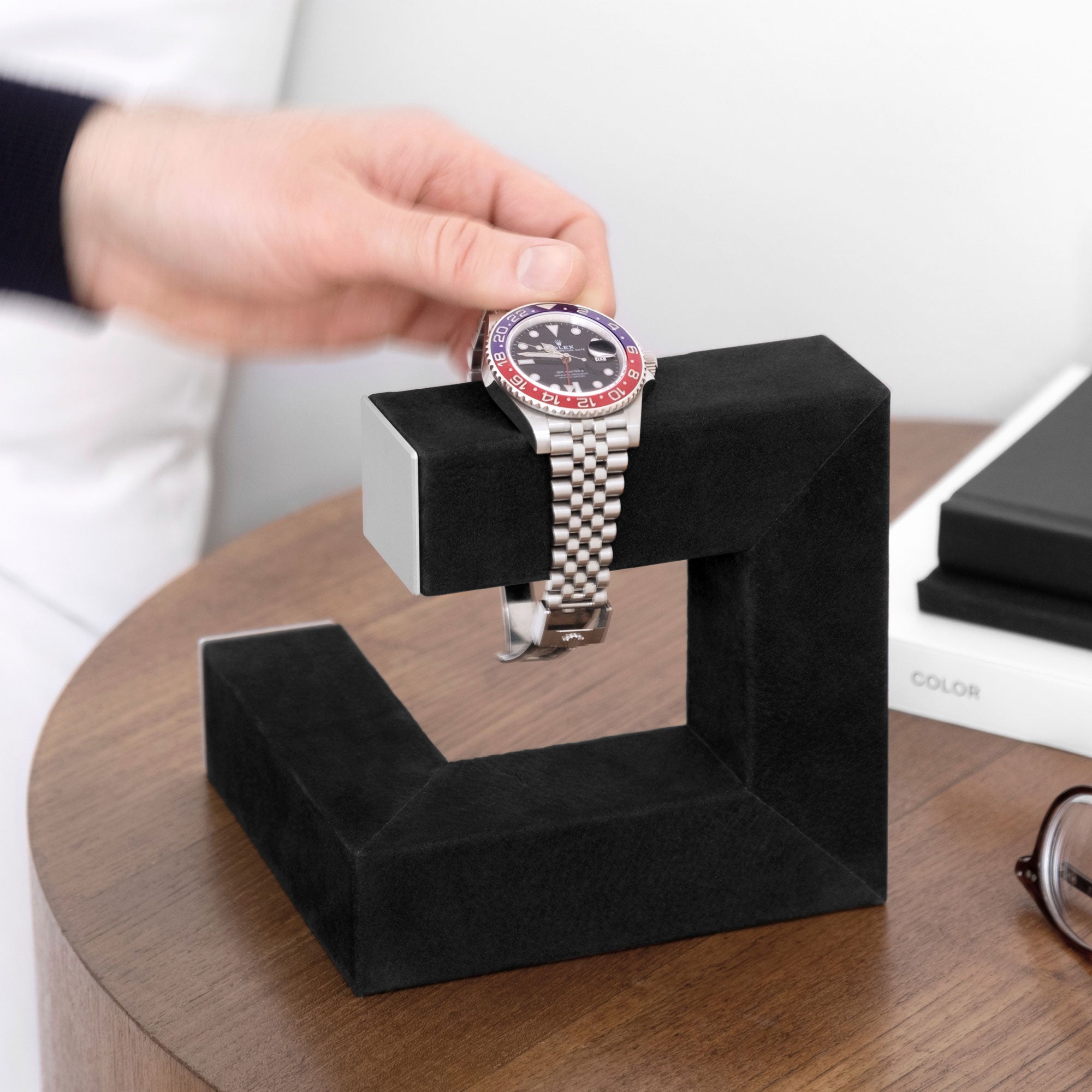 Man taking his Rolex watch from his Hudson 1 Watch stand in black nubuck leather