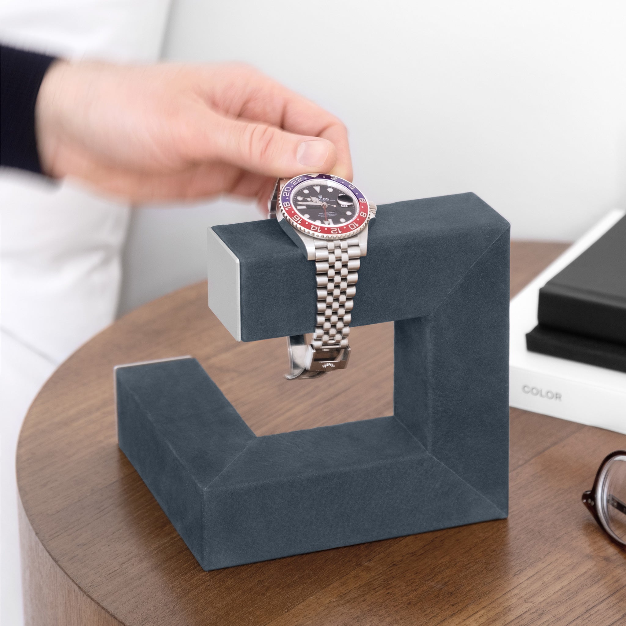 Lifestyle shot of luxury watch stand in dusty blue holding 1 Rolex GMT Pepsi watch in modern bedroom setting