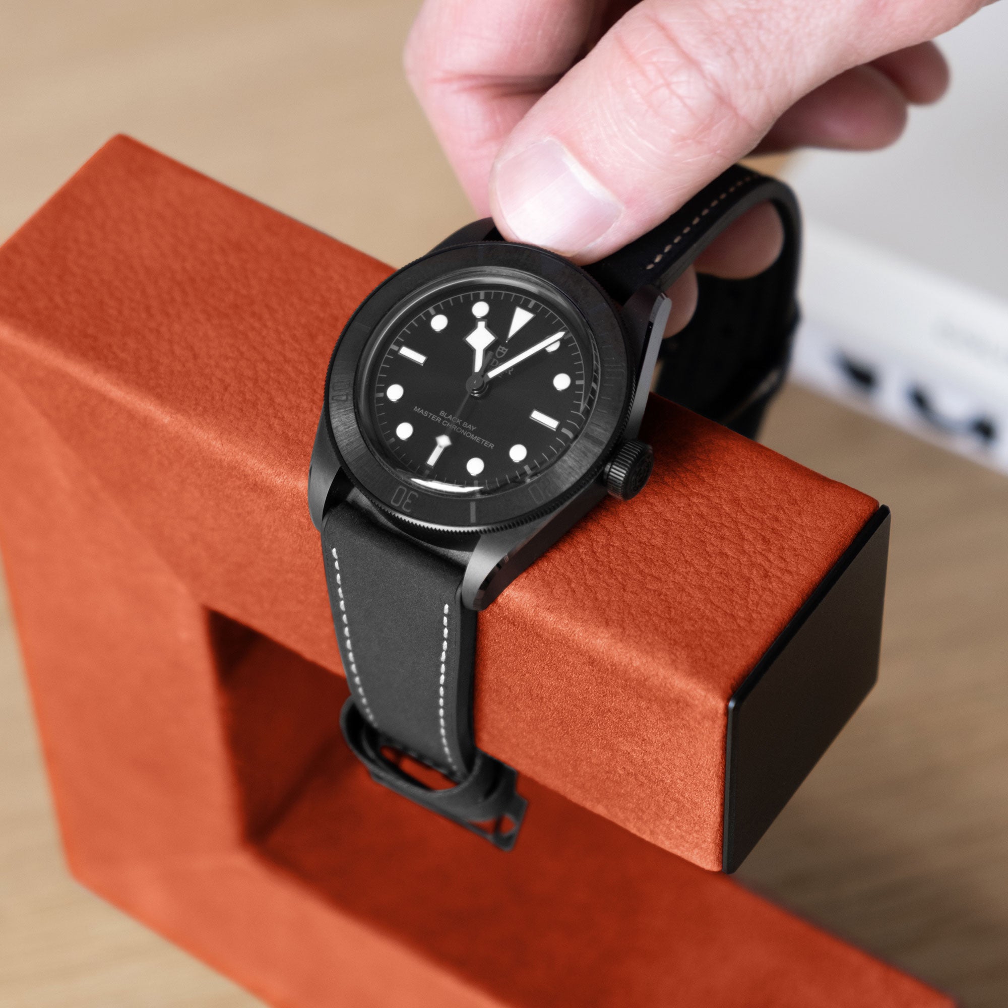 Hudson 1 minimalist watch stand holding luxury watch while it is being taken off