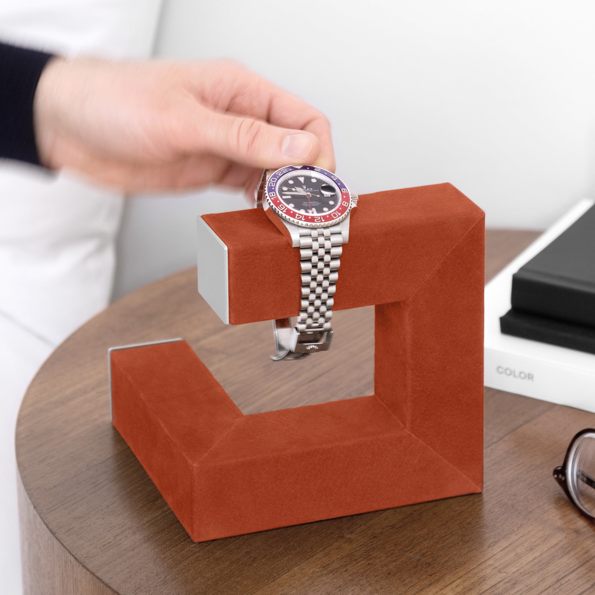 Lifestyle shot of Hudson 1 watch stand in bold pimento nubuck leather holding Rolex GMT Master 2 Pepsi