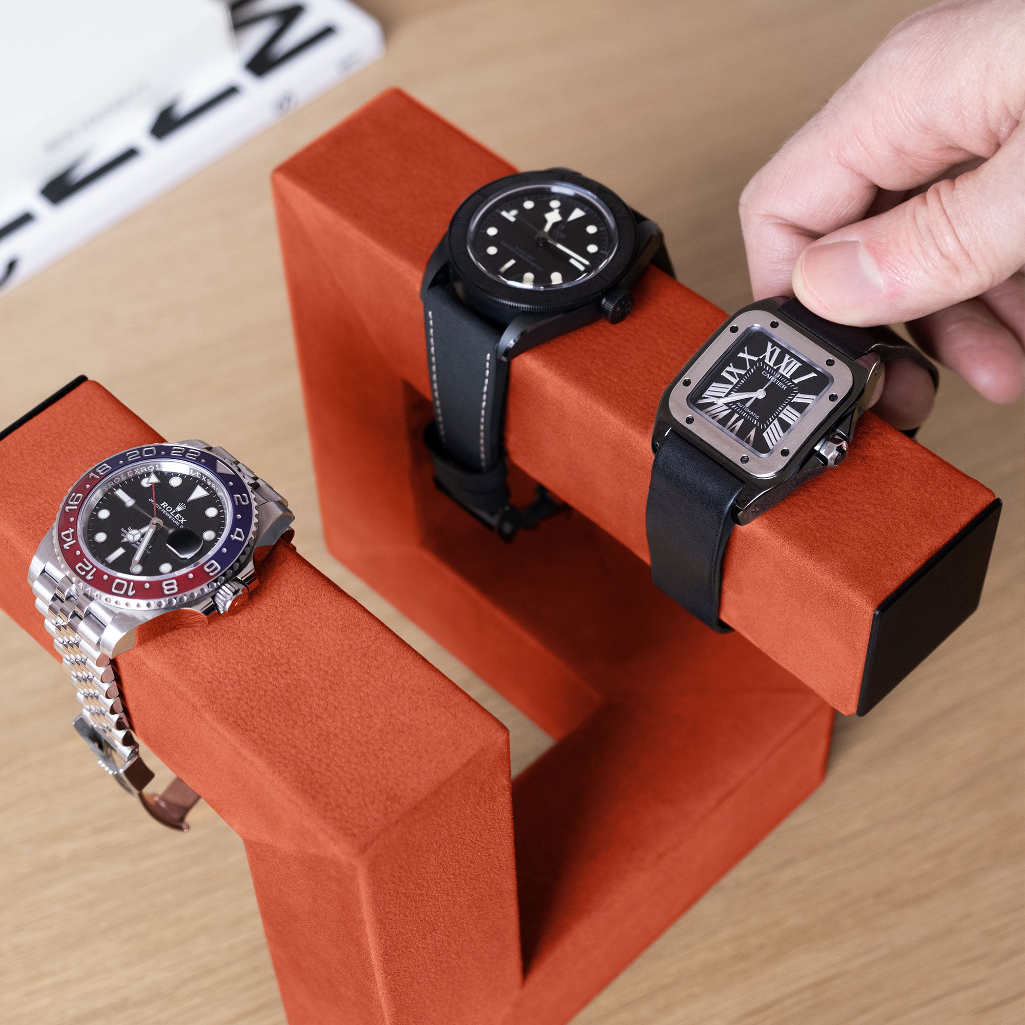 Lifestyle shot of 3 watches on designer watch stand handmade from pimento nubuck leather