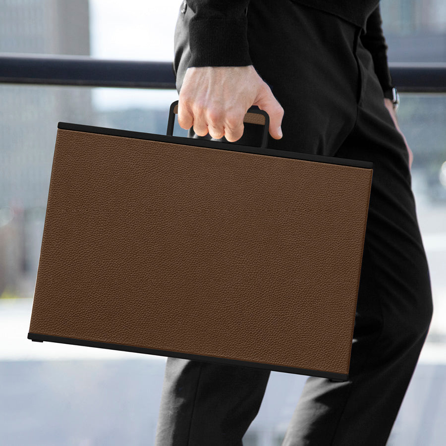 Business man carrying his black and tan leather Mackenzie briefcase on his way to work.
