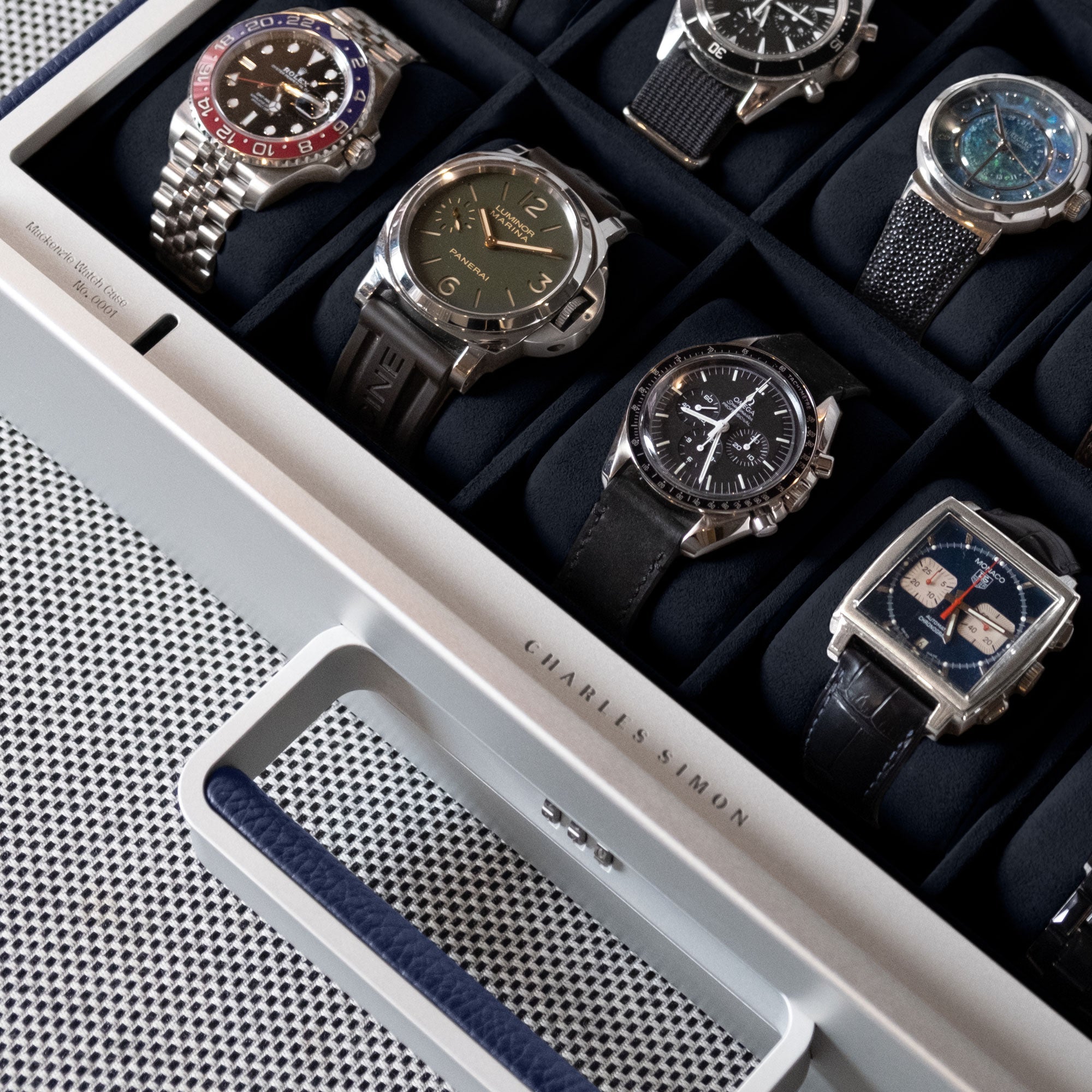 Lifestyle shot of sapphire Mackenzie 10 watch briefcase full of luxury men's watches including Omega, Rolex and Panerai