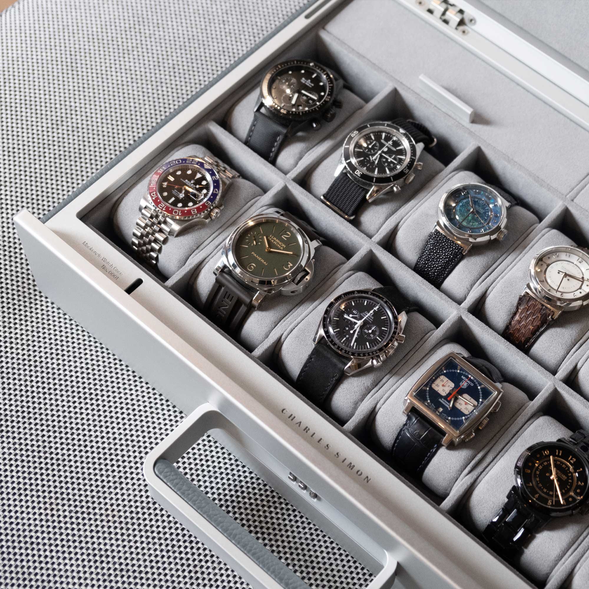 Lifestyle shot of Charles Simon handmade watch briefcase filled with luxury watches including Rolex, Panerai and Omega