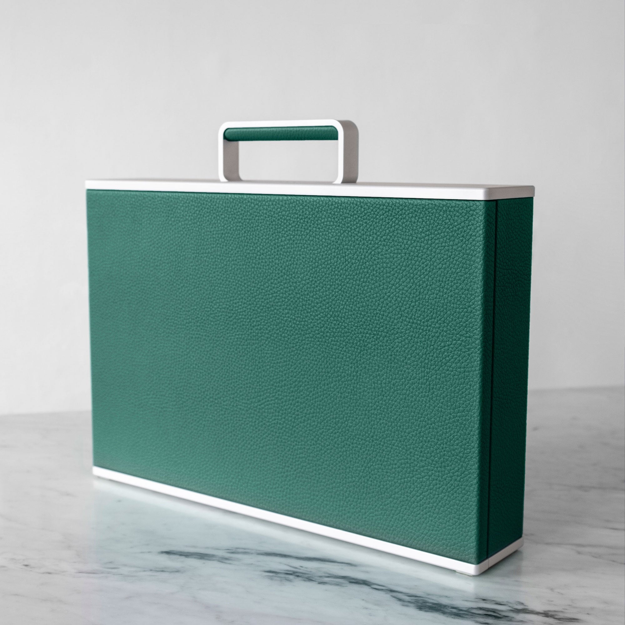 Lifestyle shot of Charles Simon Watch briefcase in emerald leather and grey anodized aluminum made by hand in Canada