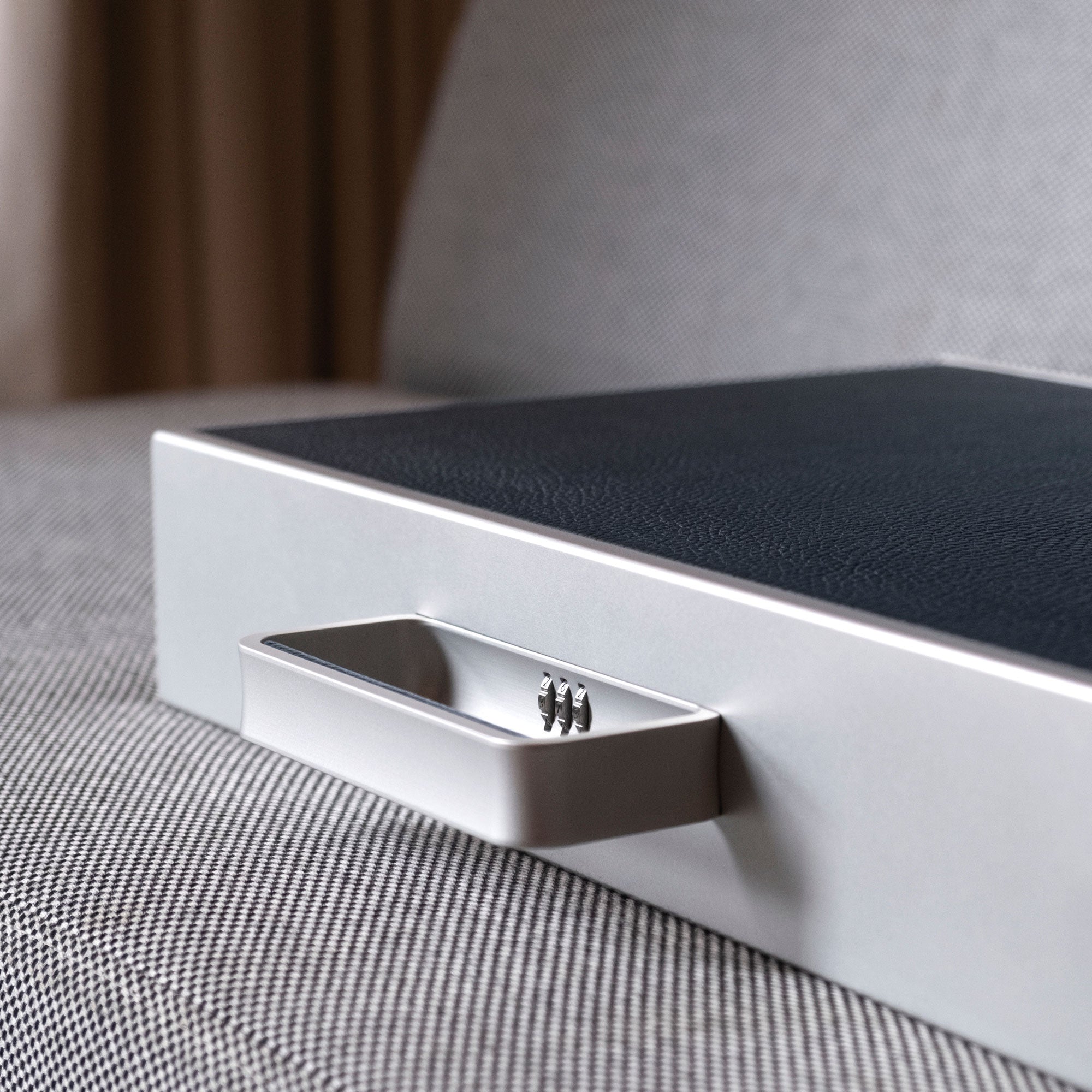 Detail lifestyle shot of Mackenzie 12 watch briefcase handle with protective lock with code in marine leather