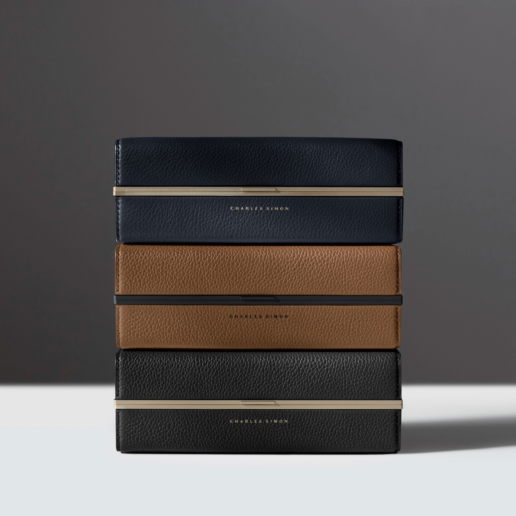 Lifestyle photo of three stacked minimalist toiletry cases by Charles SImon.