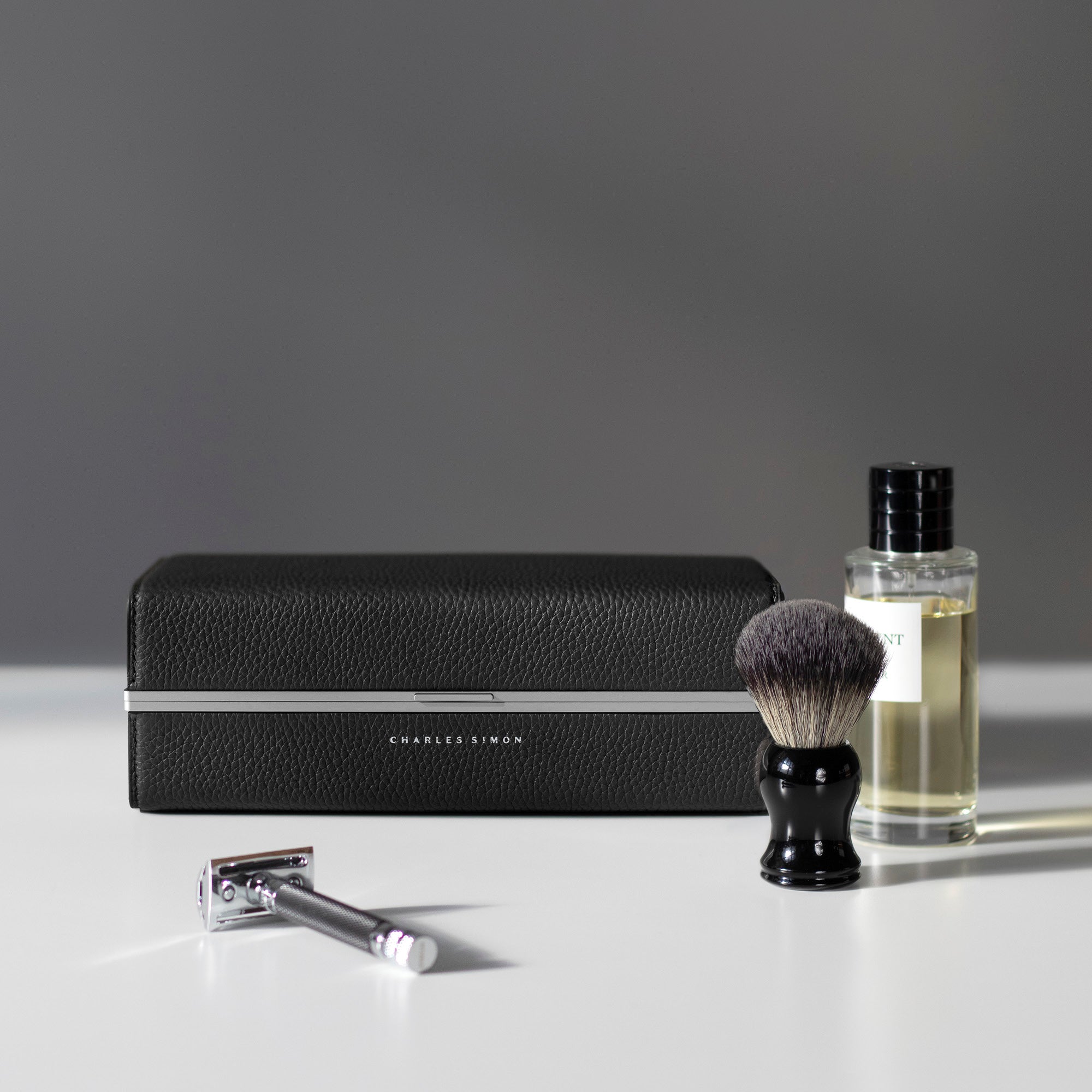 Charles-Simon_Moraine_toiletry-bag_black next to the things it can hold, perfect toiletry bag for bottle of perfume, luxury toiletry bag