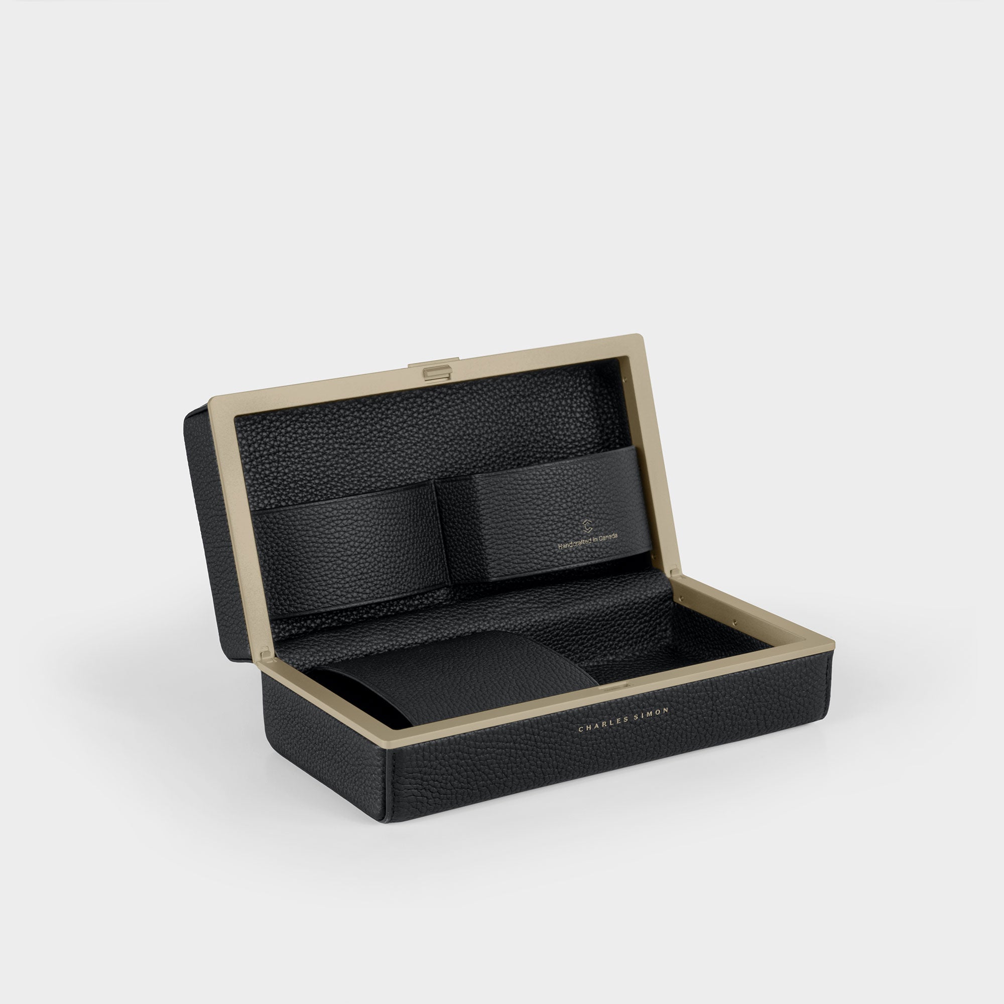 Product photo of open Moraine Toiletry bag in black leather and gold anodized aluminum. Featuring practical leather compartments in leather to organize self care products on the road