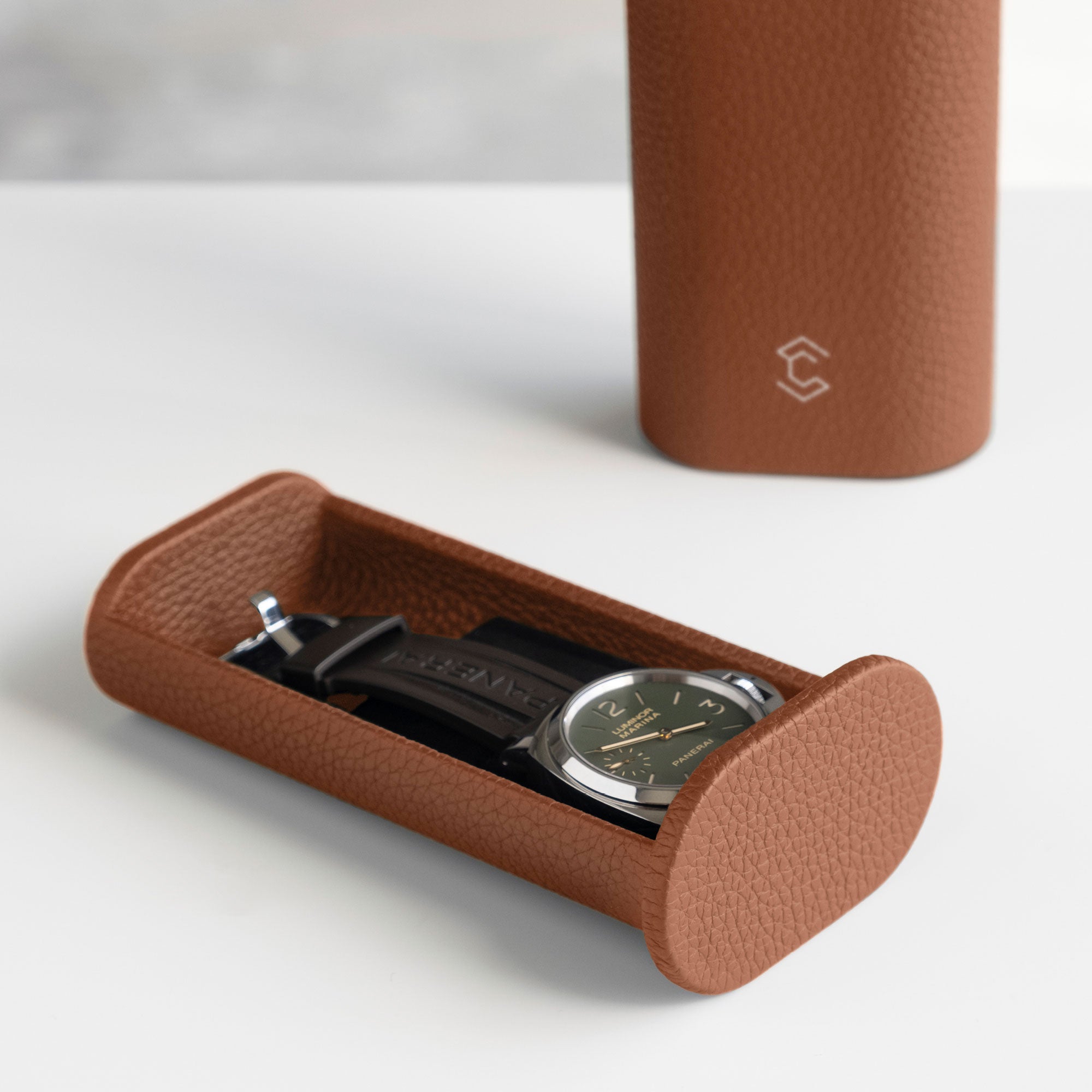 Watch with rubber strap placed in tan leather Watch roll. Handmade in Canada by Charles Simon.