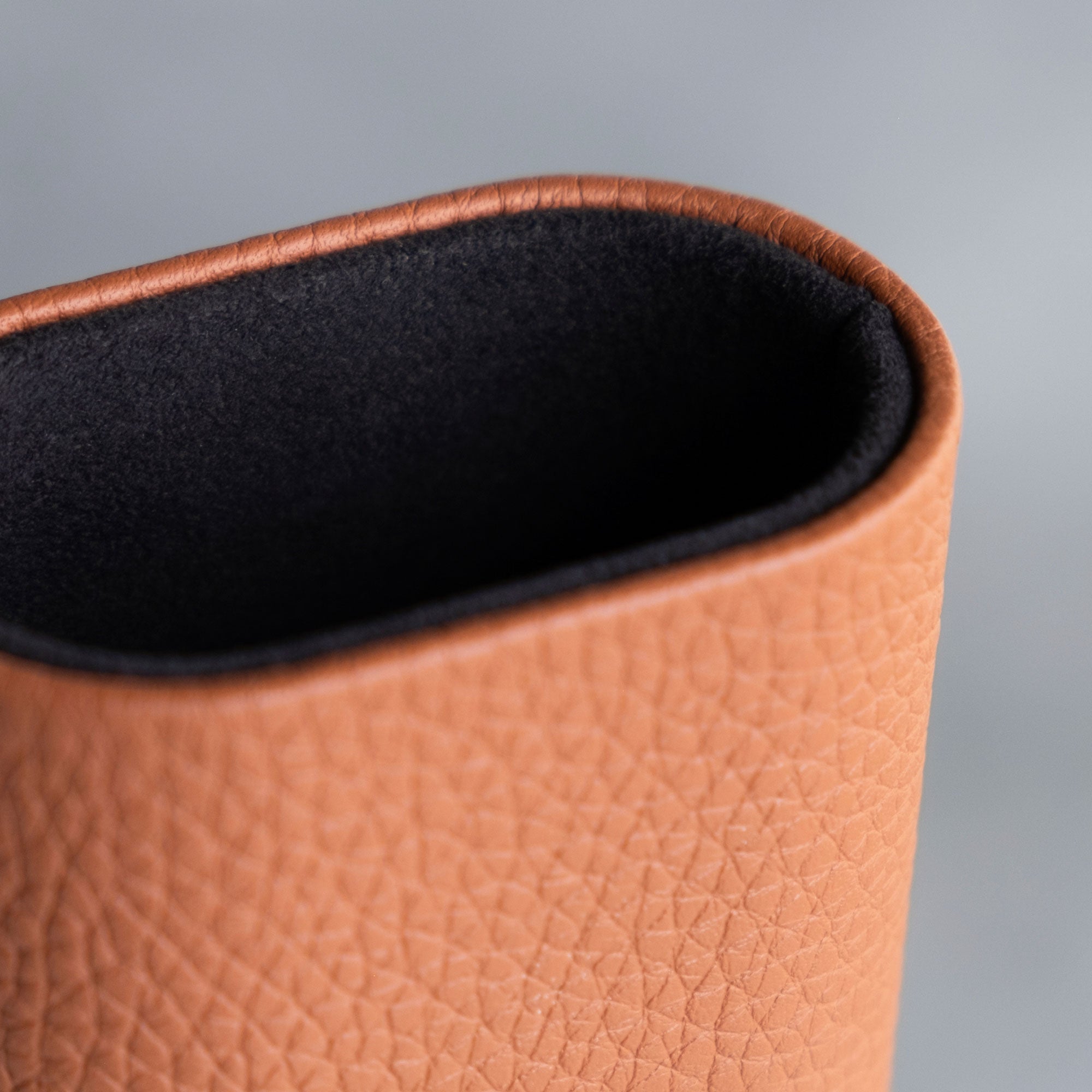 Detail of a leather watch roll in tan leather.