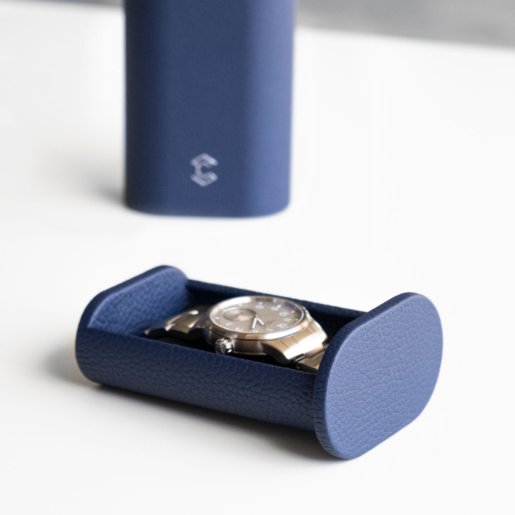 Lifestyle photo of mens watch with metal bracelet placed in sapphire leather Oscar single Watch roll.
