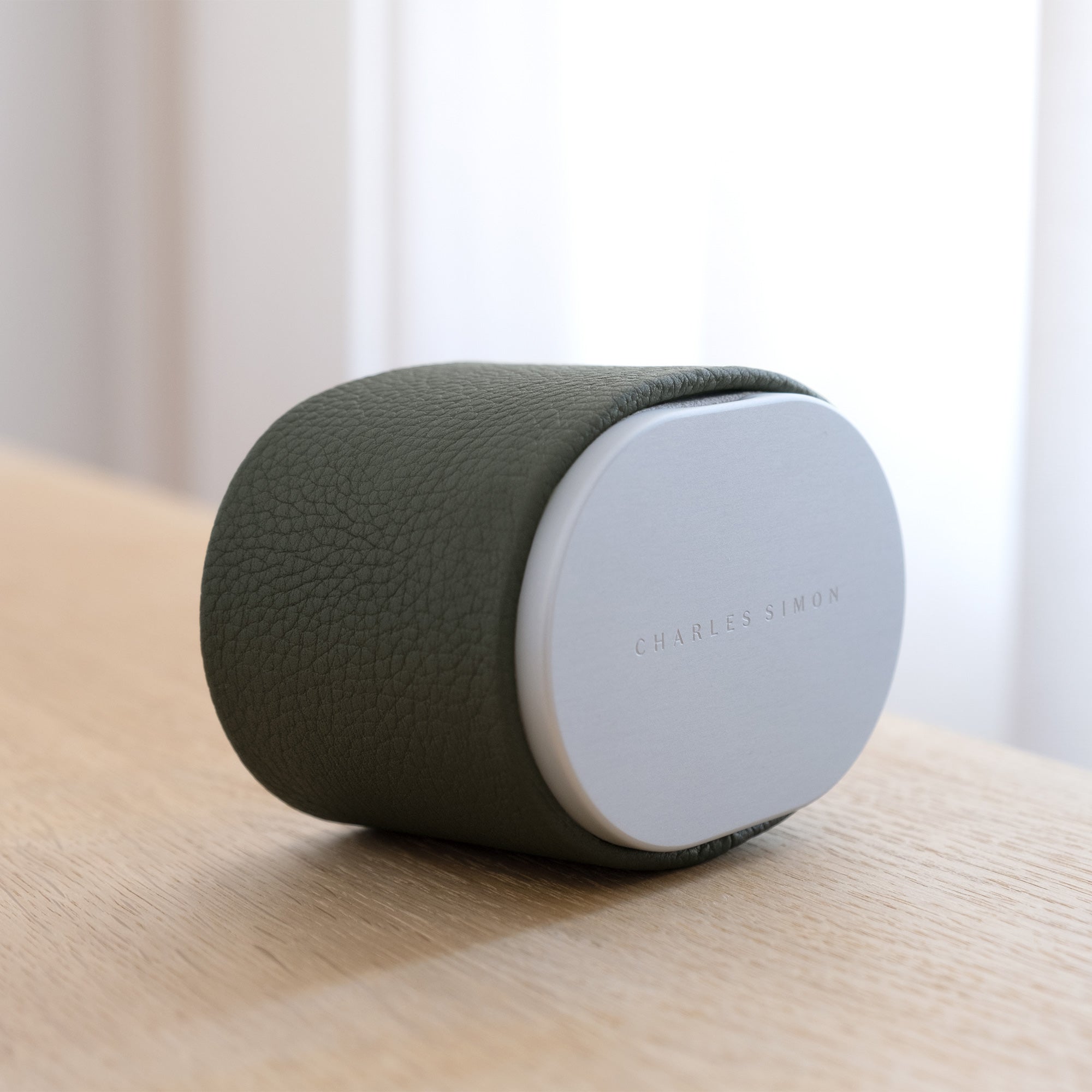 Lifestyle shot of closed travel watch roll by Charles Simon. Handmade in Canada from khaki leather and anodized aluminum.