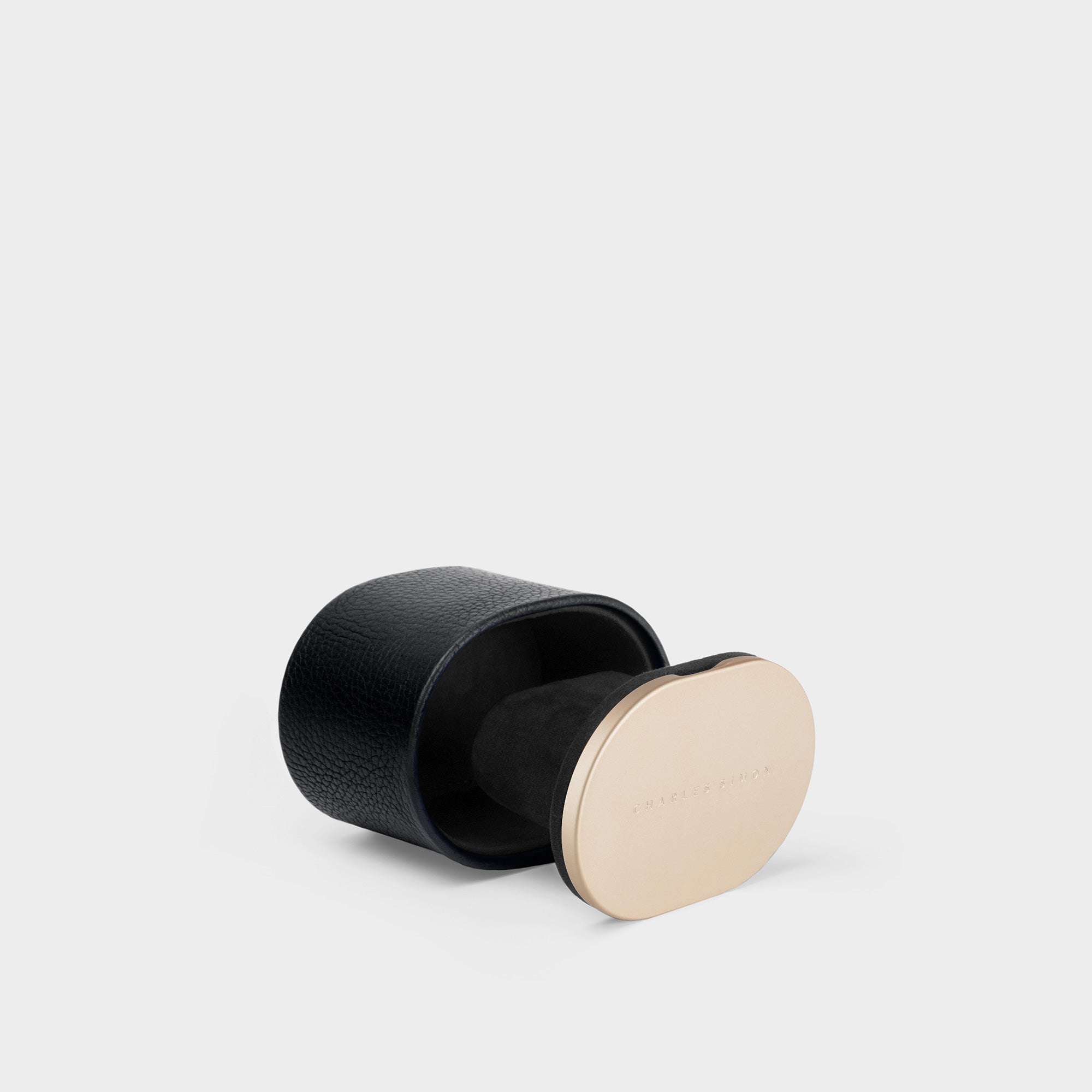 Product photo showing side view of the Theo Watch roll in black leather and gold colored aluminum. Handmade to hold 1 watch