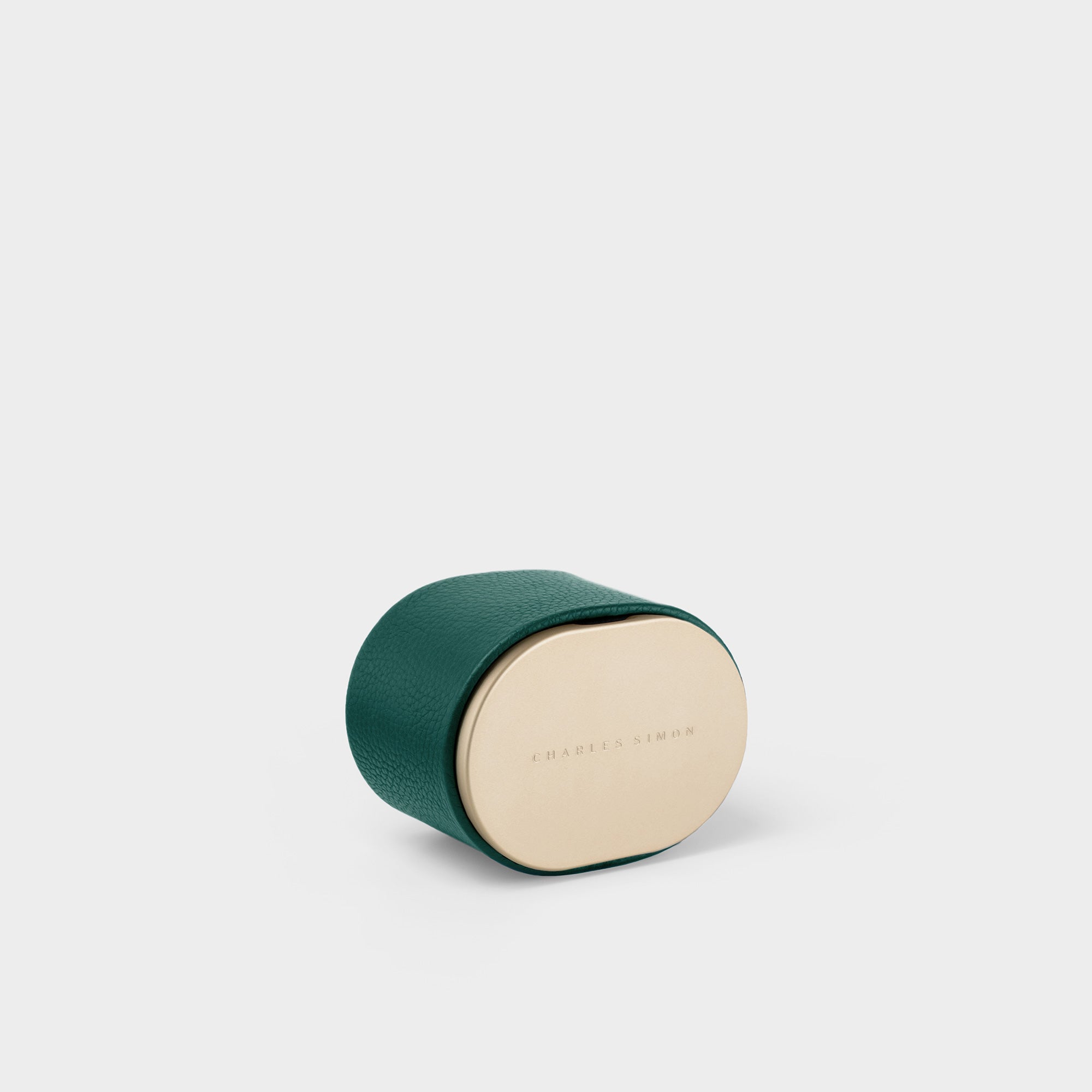 Product photo of closed gold and emerald Theo Watch roll. Handmade to hold, transport and display your favorite watch.