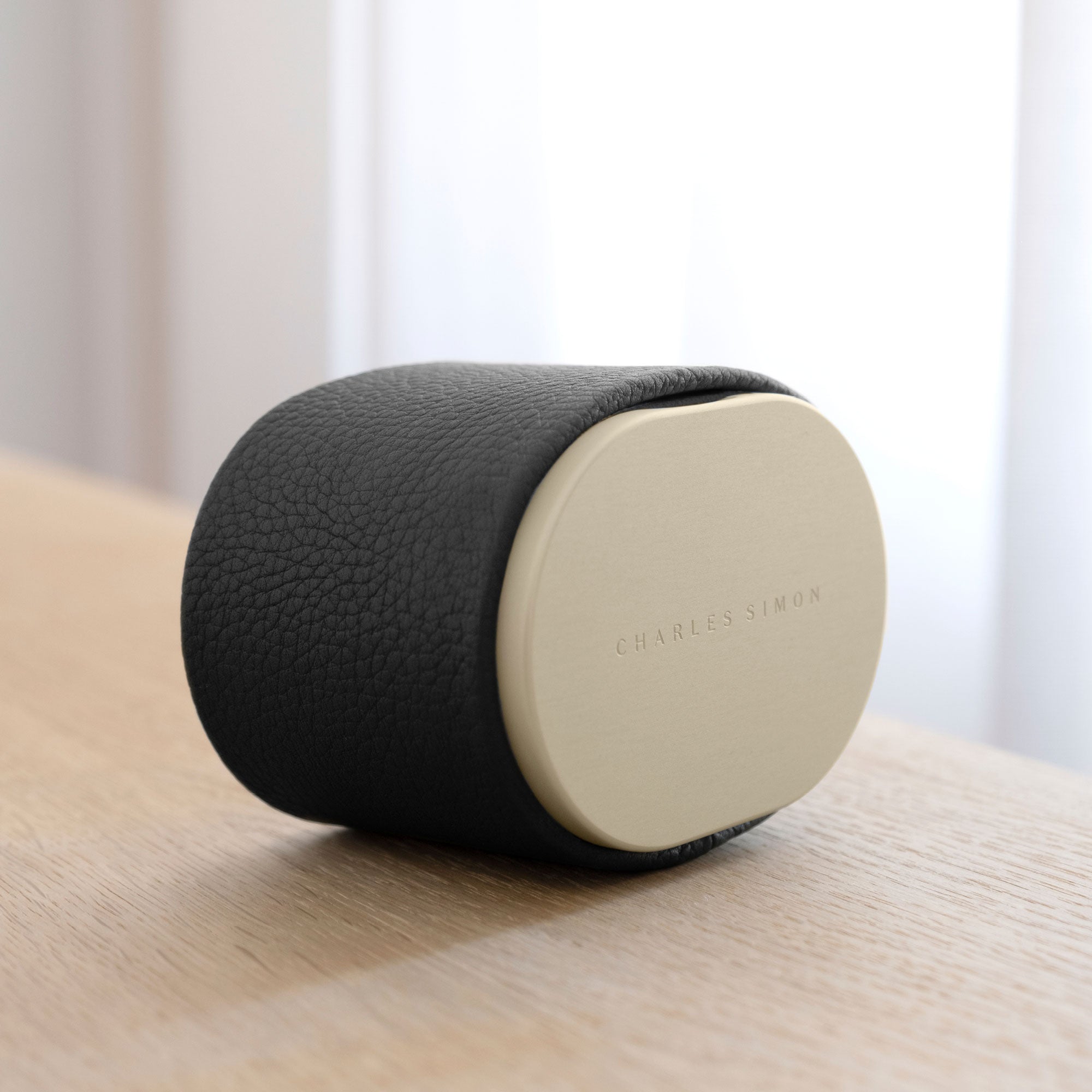 Lifestyle photo of closed Theo Watch roll in gold anodized aluminum and black leather. Handmade in Canada from premium materials.