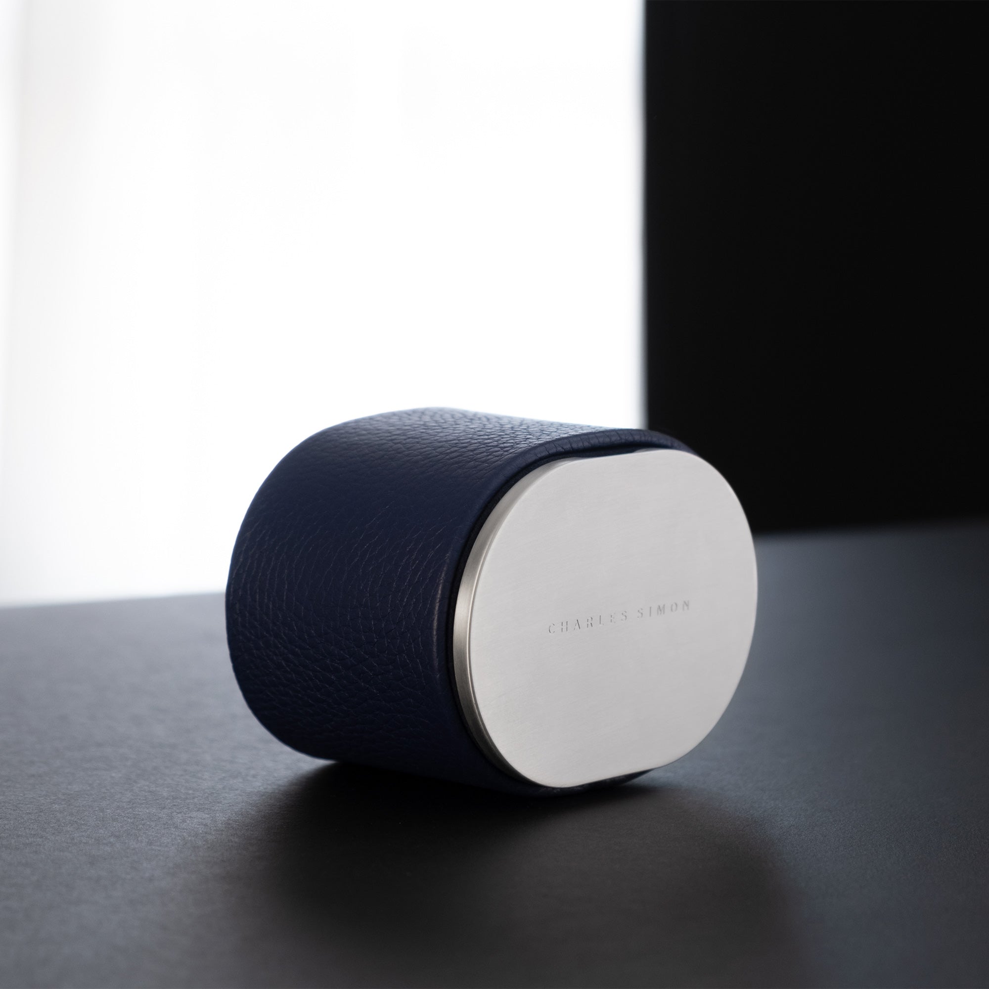 Lifestyle photo of closed Theo Watch roll in sapphire leather and grey anodized aluminum. Handmade in Canada.