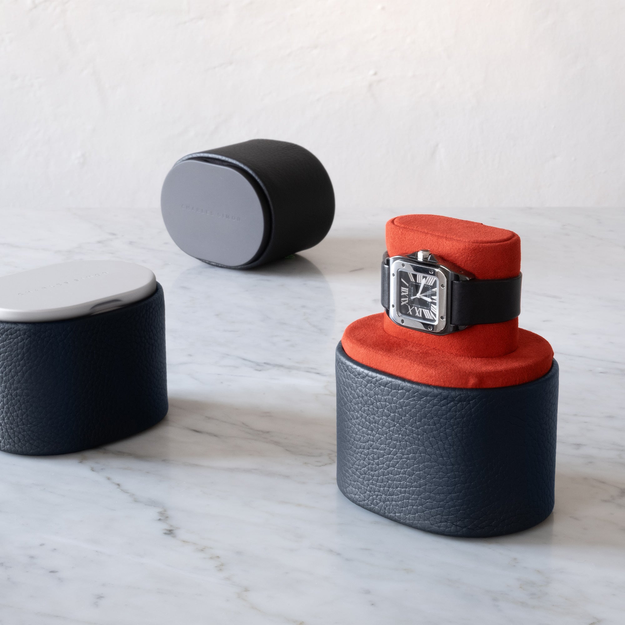 Lifestyle shot of luxury Theo watch rolls for one watch handmade from marine leather and vibrant Vermilion interior