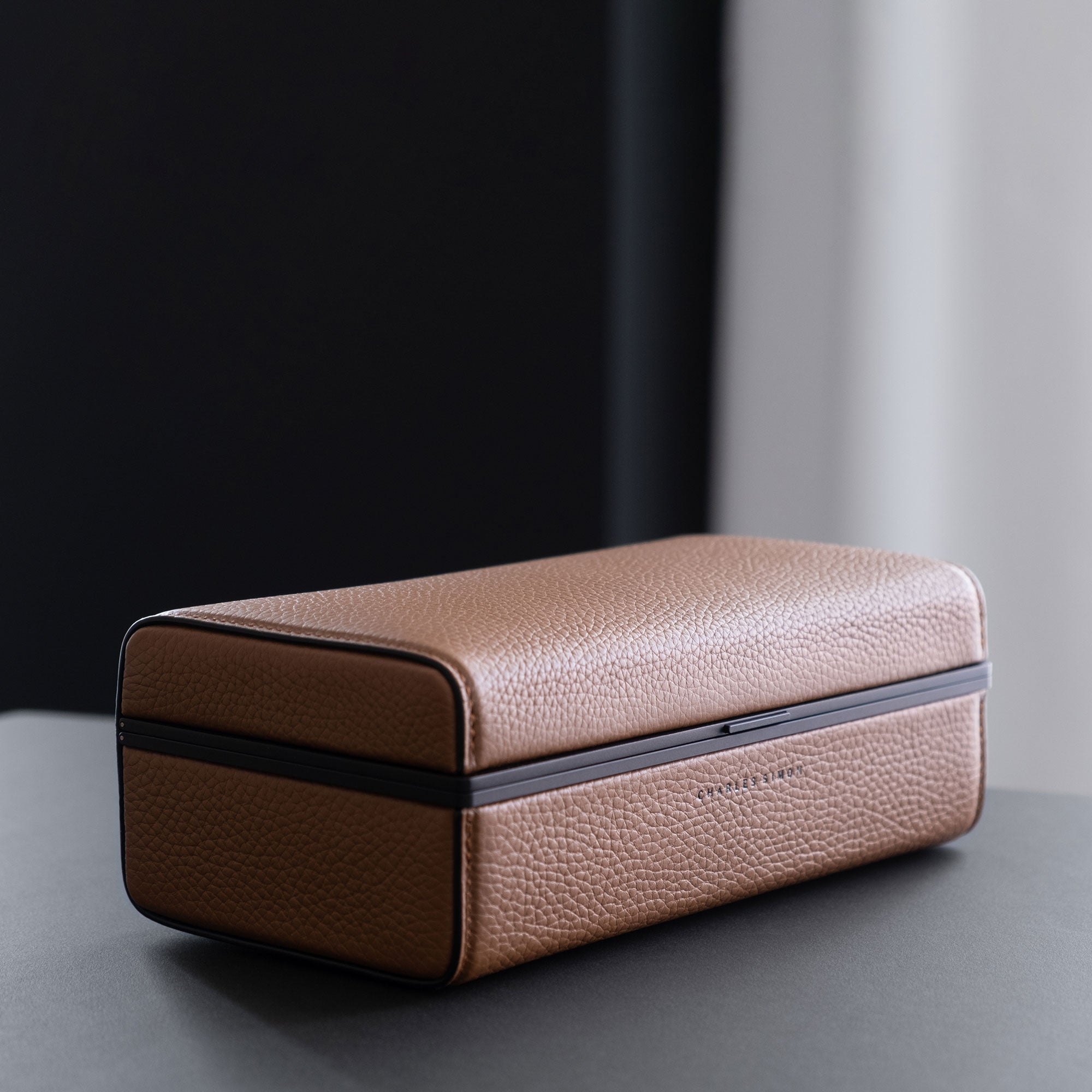 Lifestyle photo of closed tan leather Charles Simon Eaton 3 watch case