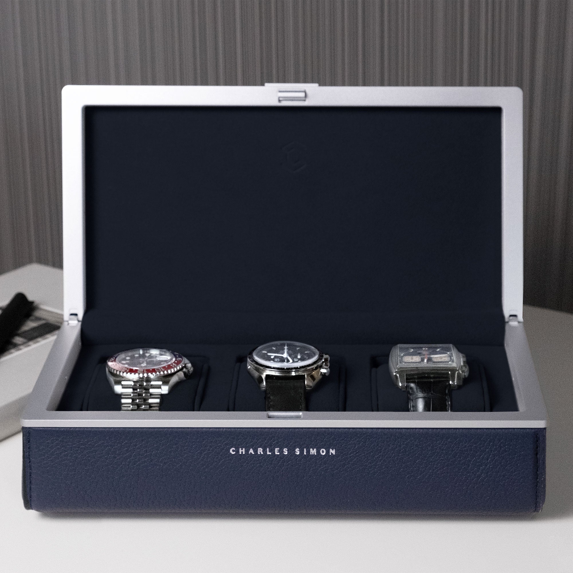 Front view of Eaton 3 watch case in sapphire holding three luxury men's watches