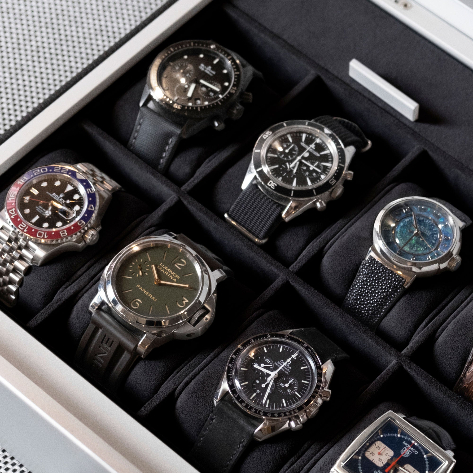 Detail shot of luxury watches including Panerai, Omega, Tag Heuer, Rolex and Jaeger LeCoultre displayed in Spence 12 Watch box by Charles Simons