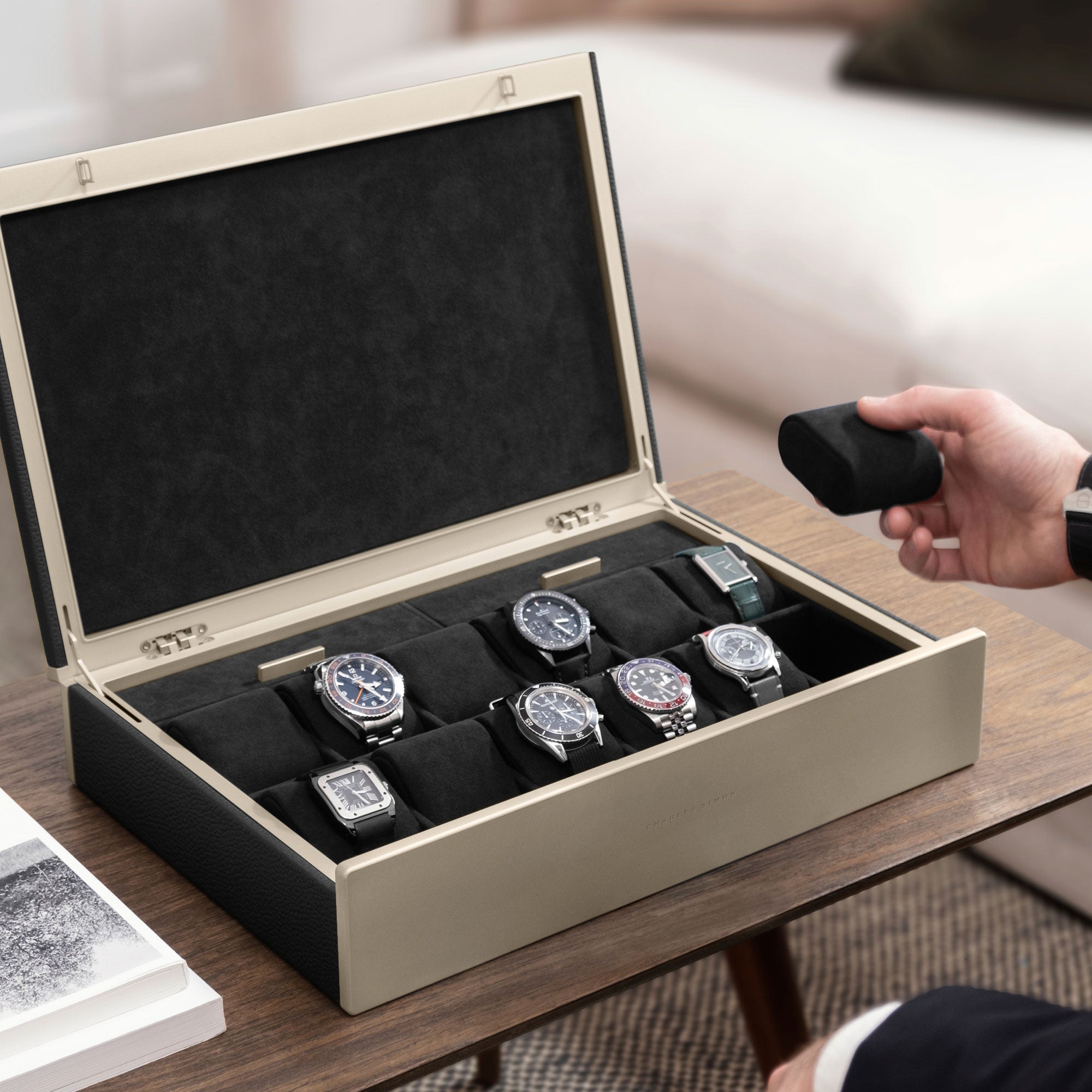 Man holding black removable cushion from bis black leather and gold accents Spence 12 Watch box for his collection of up to 12 watches.