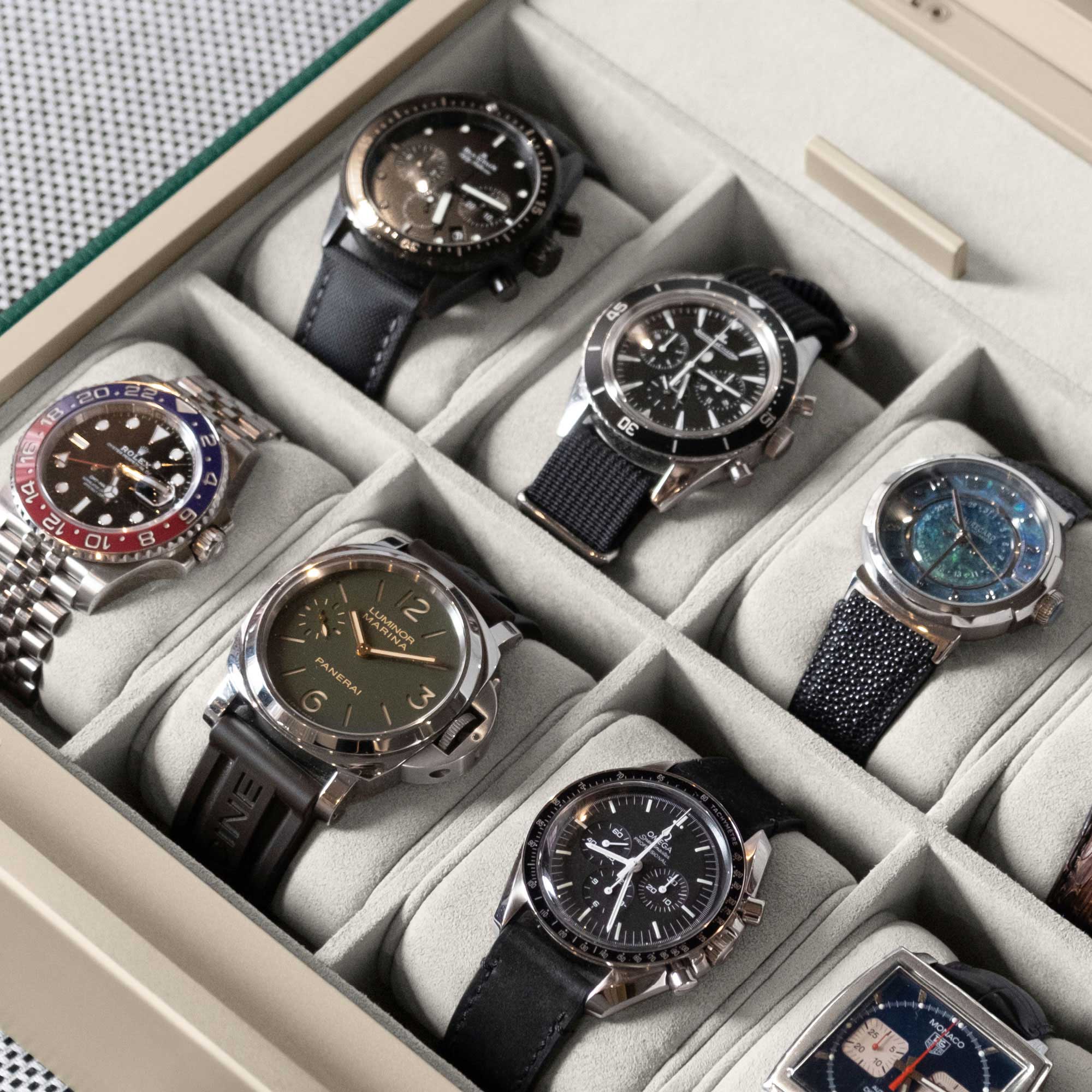 Detail photo of luxury watches displayed in a Spence 12 Watch box in eggshell interior and emerald leather