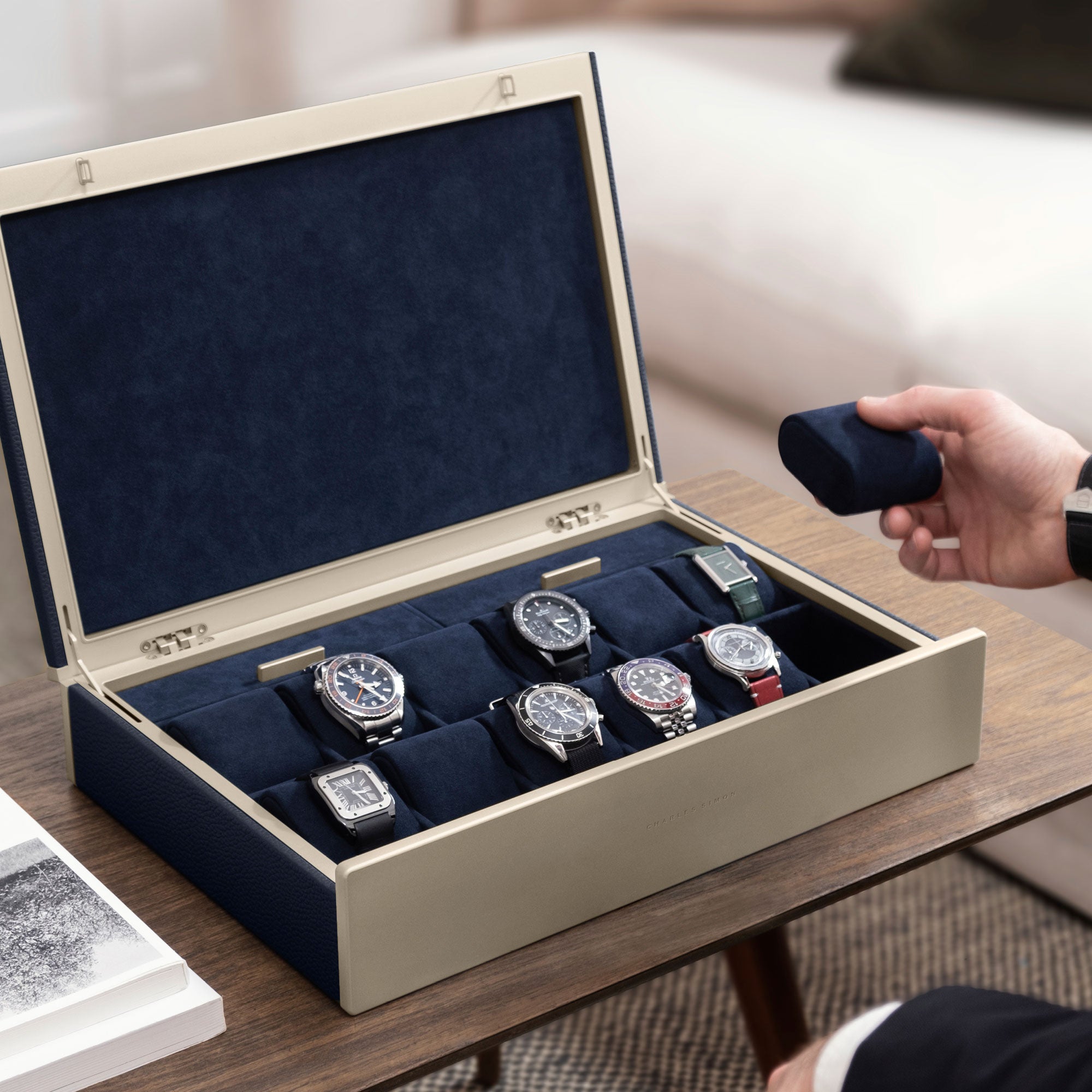 Lifestyle photo of man taking a removable watch cushion in deep blue from his Spence 12 Watch box