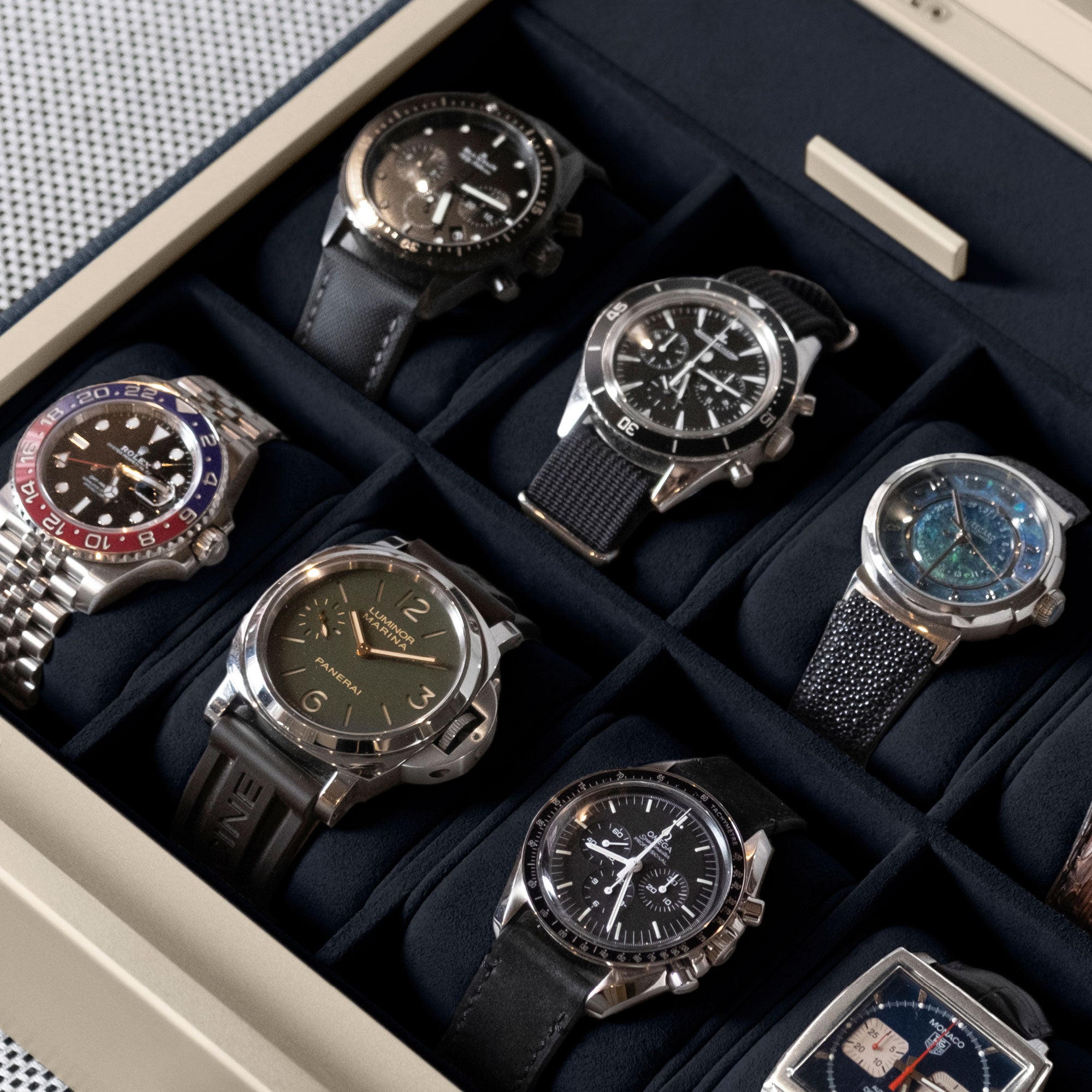 Detail photo of luxury watches displayed in a Spence 12 Watch box in deeo blue interior and marine leather