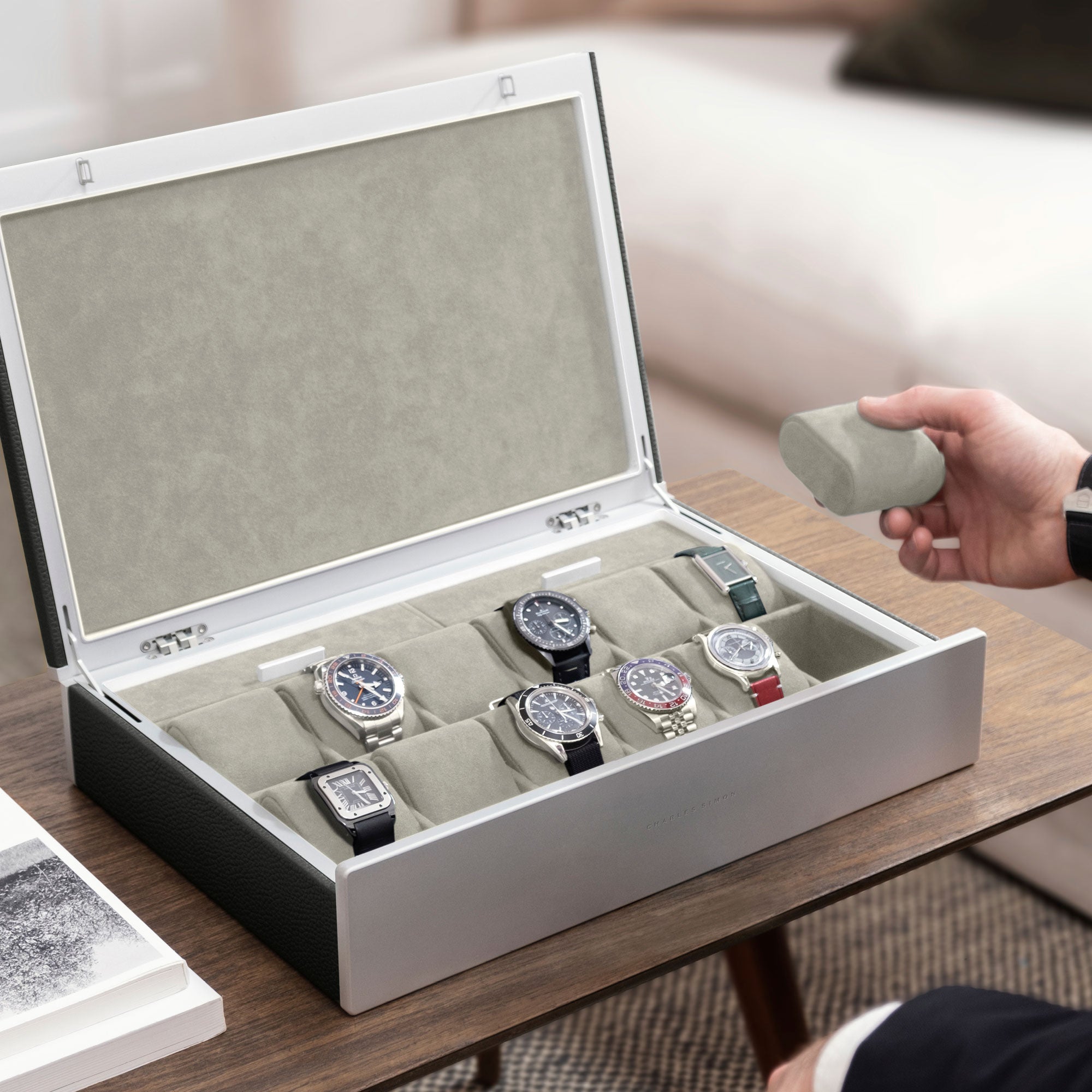 Man opening graphite leather and seasand interior Spence 12 Watch box with luxury watch collection displayed inside