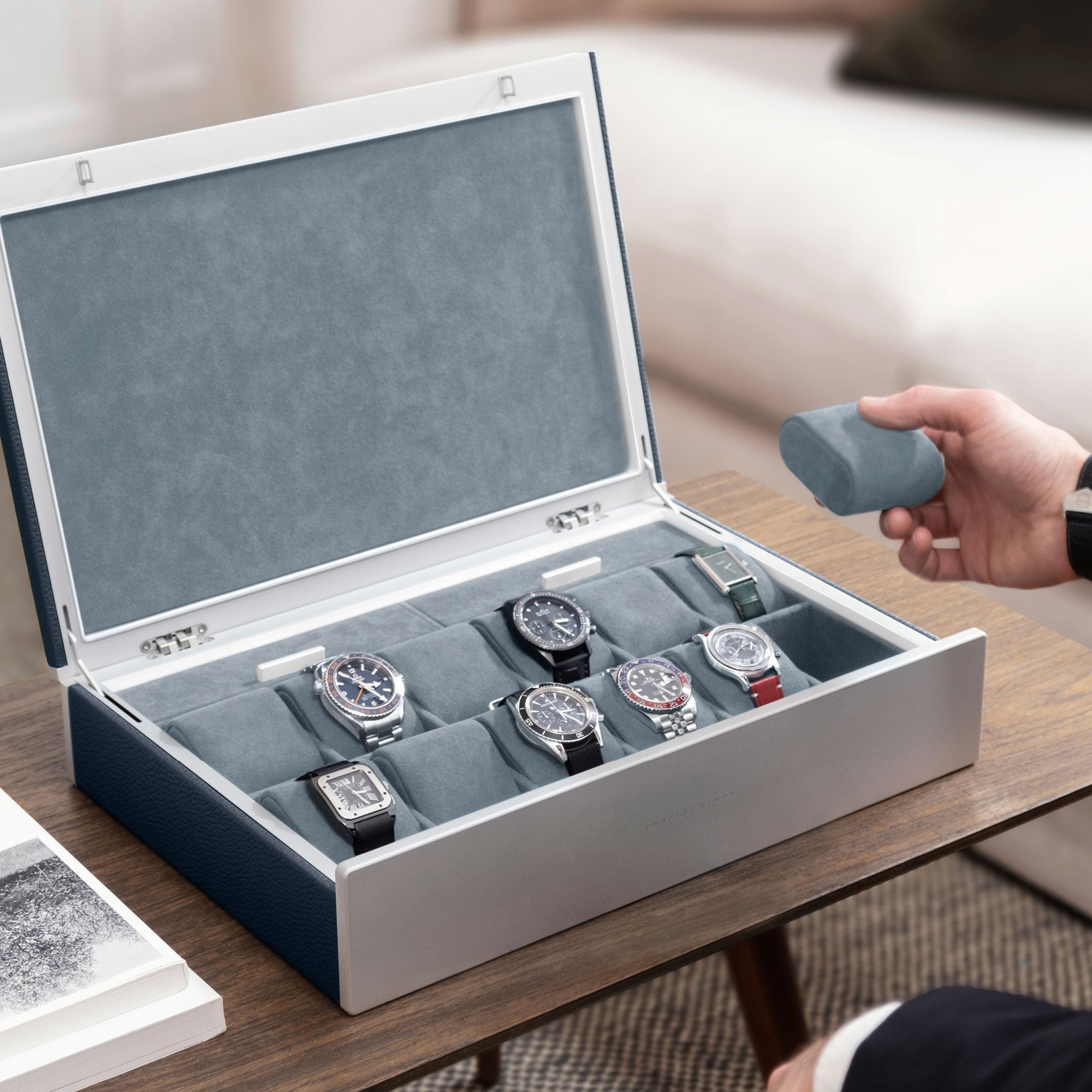 Lifestyle photo of man opening marine leather Spence 12 Watch box with luxury watch collection displayed inside