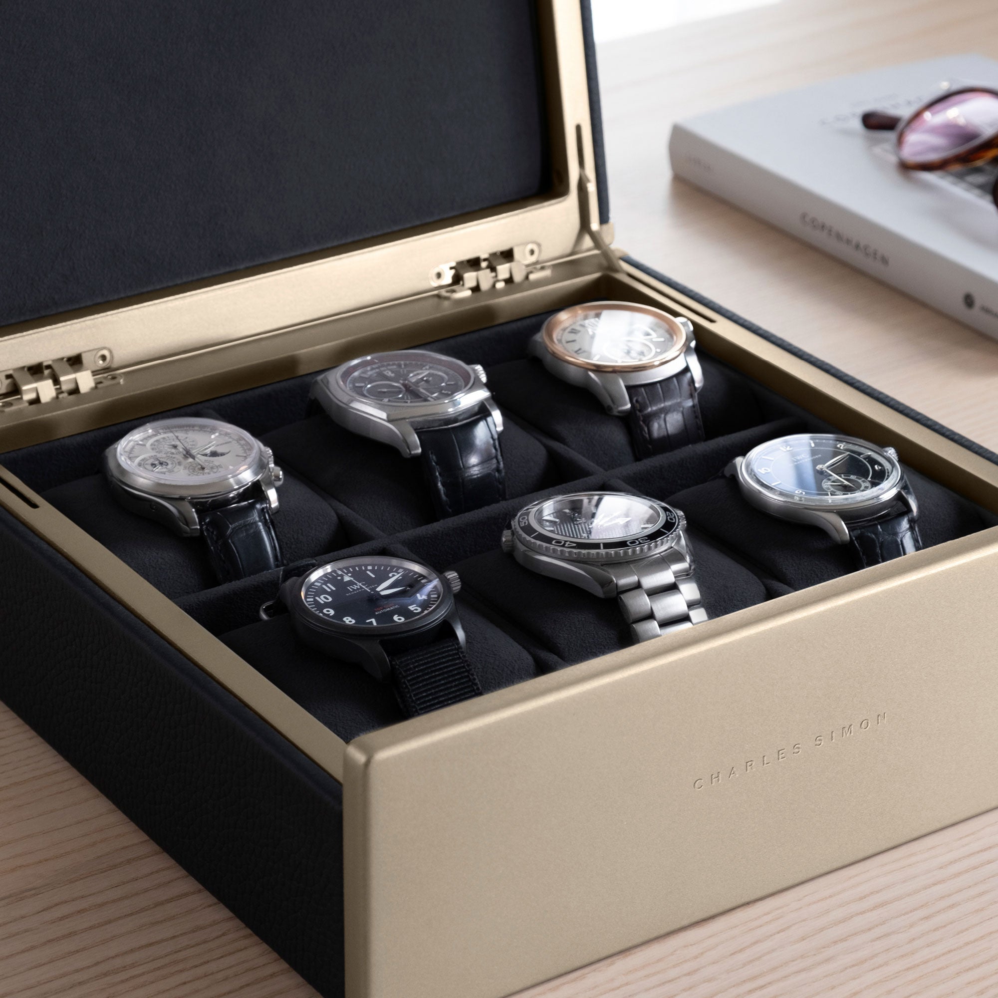 Detail photo of watch collection of 6 watches displayed in the gold Spence 6 watch box in black leather. 