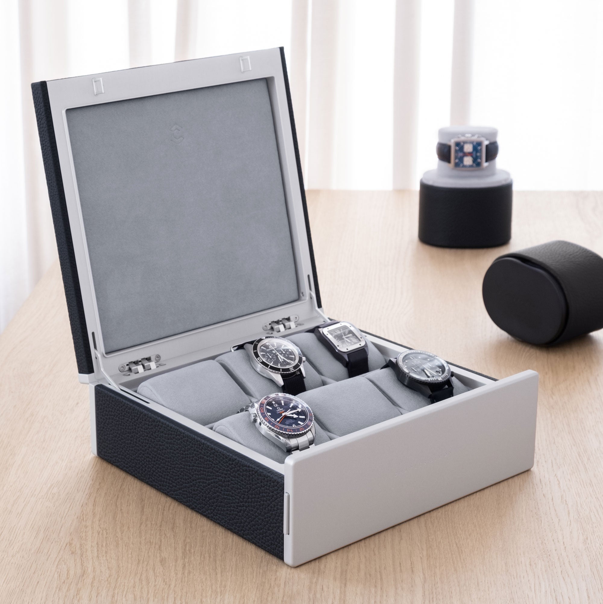 Lifestyle photo of luxury watch collection displayed in Spence 6 Watch box in marine leather. 