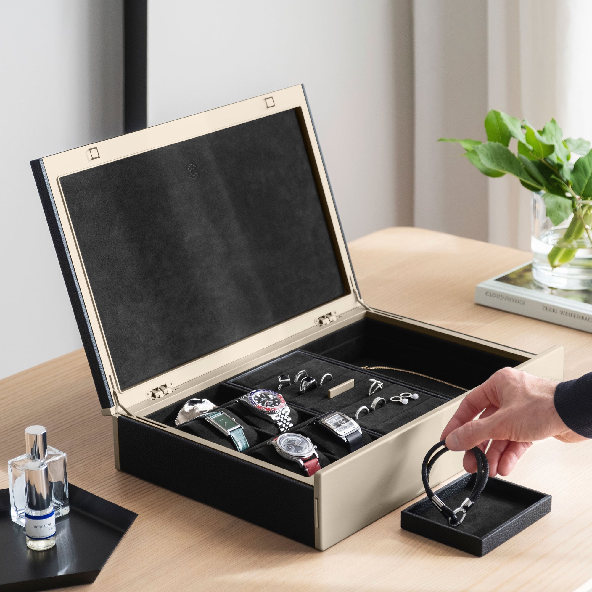 Man taking bracelet from removable jewelry organization tray. The Taylor 4 is also storing 4 luxury timepieces as well as multiple rings and necklaces.