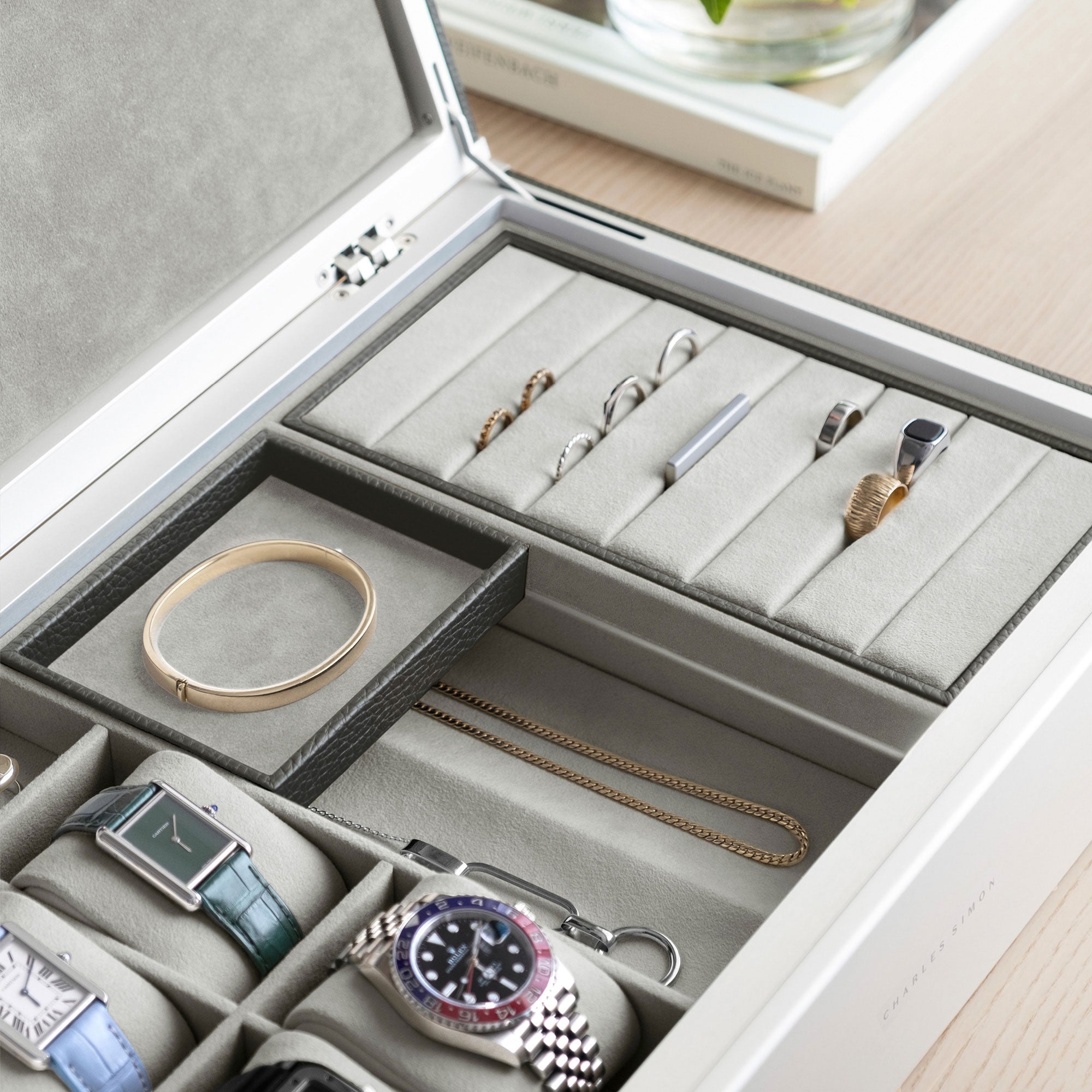 Detail photo of rings , gold bracelet, gold necklace and luxury watches stored and organized in the Taylor 4 Watch and Jewelry box in graphite leather and sea sand Alcantara for elevated Watch and Jewelry storage. 